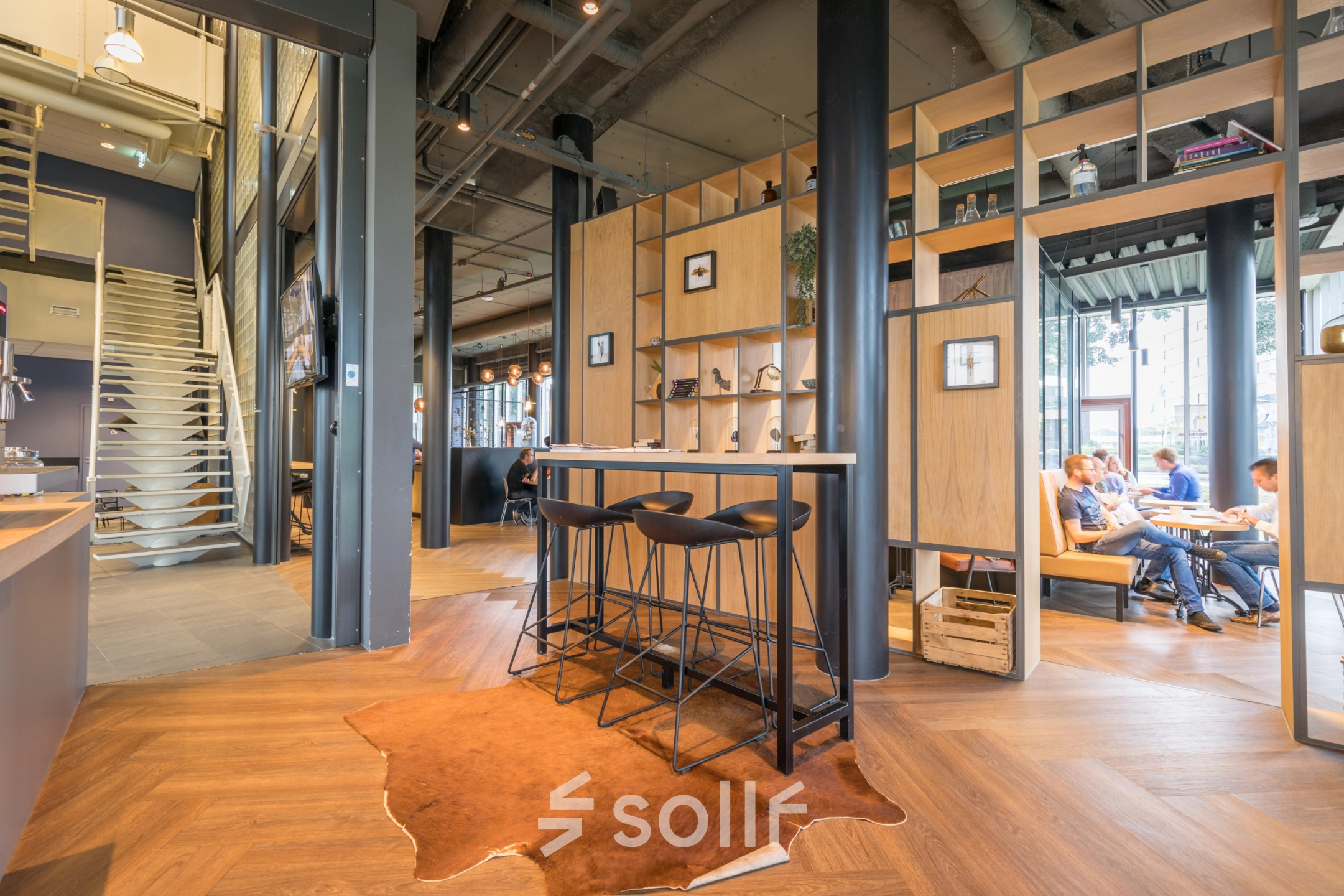 Stylish office space at Maanlander 47, Amersfoort Calveen, featuring modern furnishings and people collaborating at tables, ideal for office space rental.