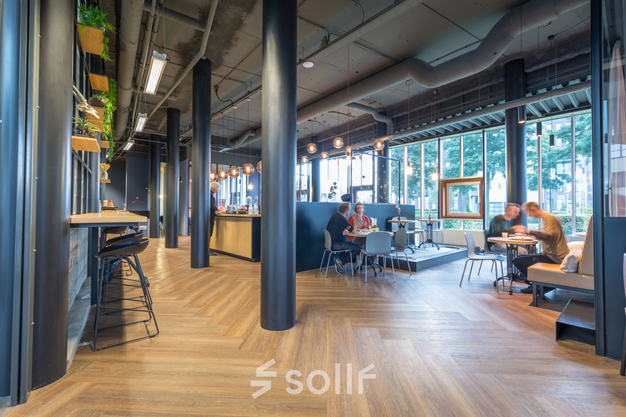 Modern office space at Maanlander 47, Amersfoort Calveen, featuring a furnished open floorplan with people engaging in discussions, ideal for rent office space needs.