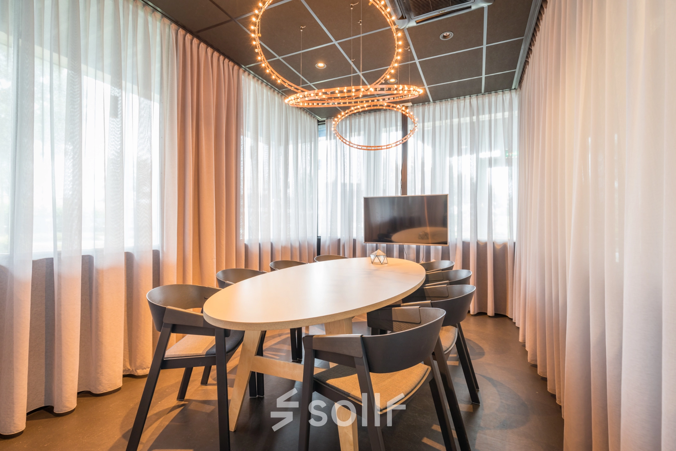Bright office space rental at Maanlander 47, Amersfoort Calveen, featuring a well-lit conference room with stylish lighting and a flat-screen TV.