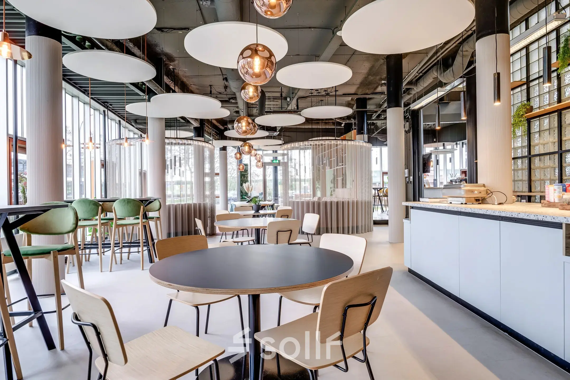 Modern office space with round tables, chairs, and circular ceiling lights, situated at Maanlander 47, ideal for office space rental in Amersfoort Calveen.
