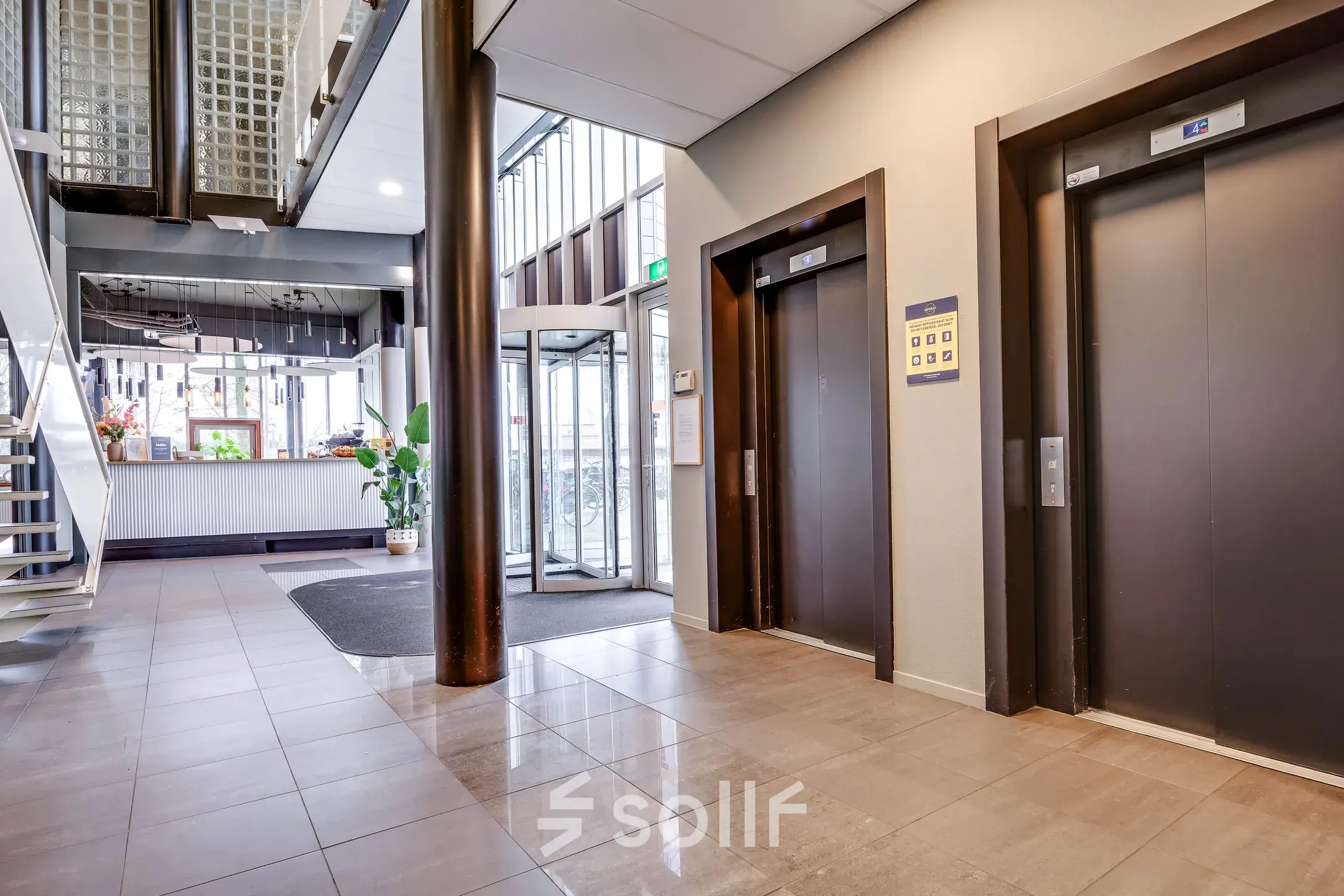 Bright office entrance at Maanlander 47, Amersfoort Calveen, showcasing elevators and a reception desk with office space rental opportunities.