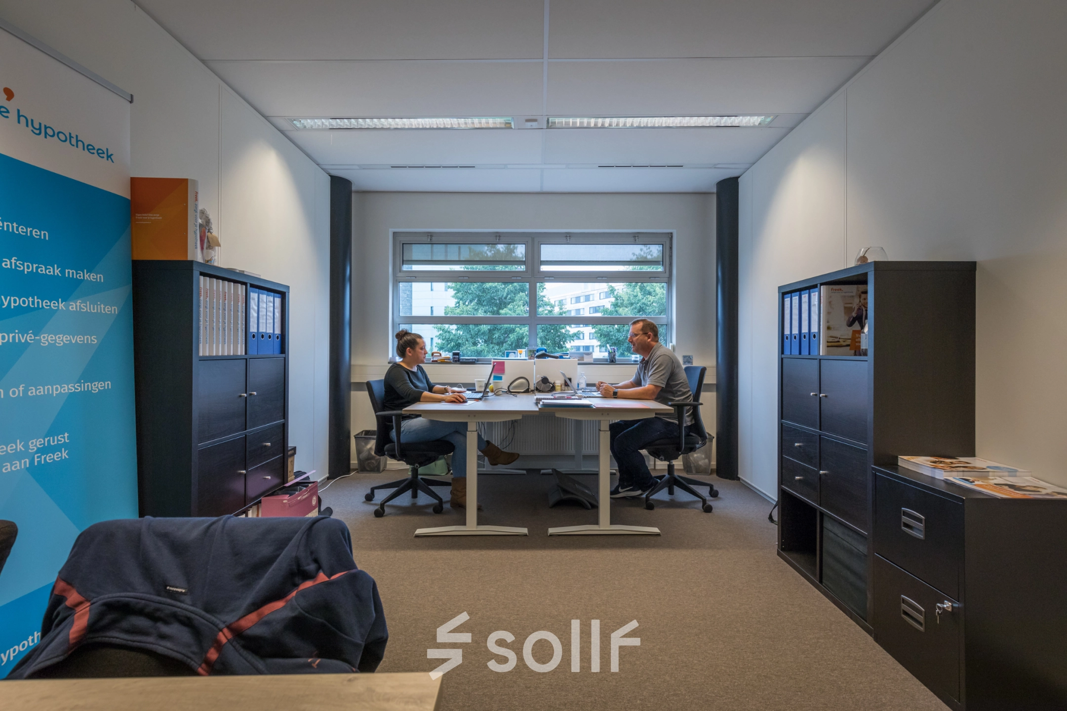 Two people working at desks in a furnished office space at Maanlander 47, Amersfoort Calveen, ideal for rent office space seekers.