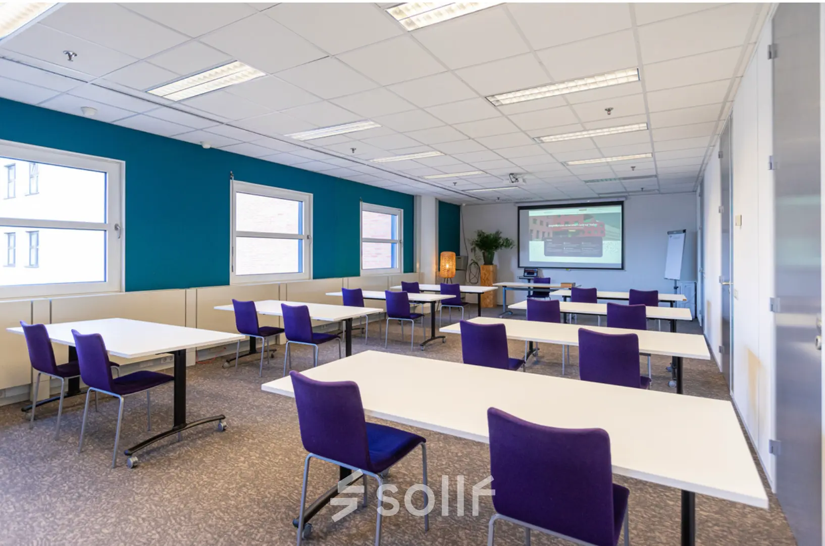 Bright office space with tables and purple chairs ideal for office space rental at Stationsplein 49, Amersfoort Centraal Station.