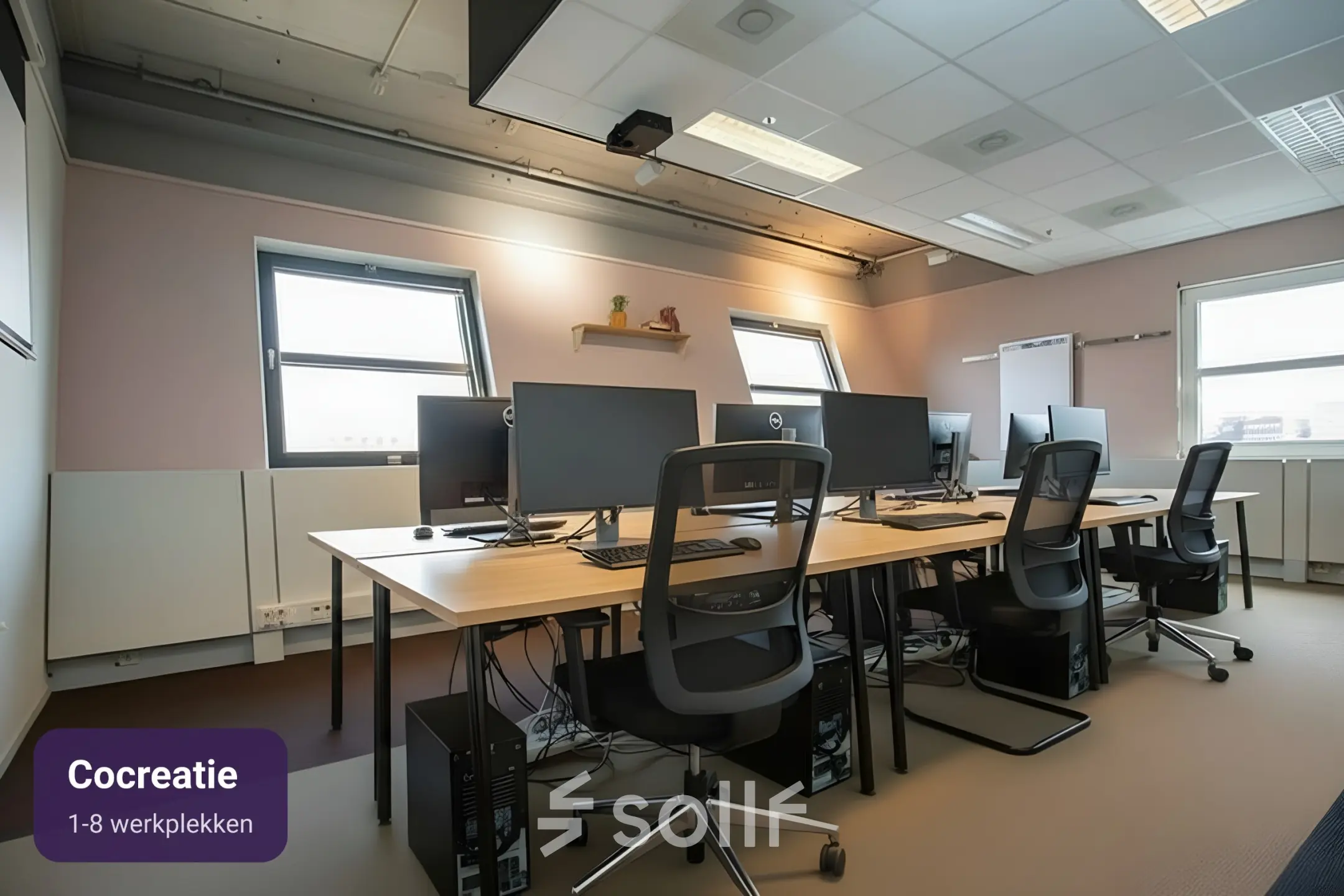 Bright office to rent at Stationsplein 49 with multiple workstations and modern monitors, ideal for collaborative work. Part of Amersfoort Centraal Station's dynamic workspace rental options.