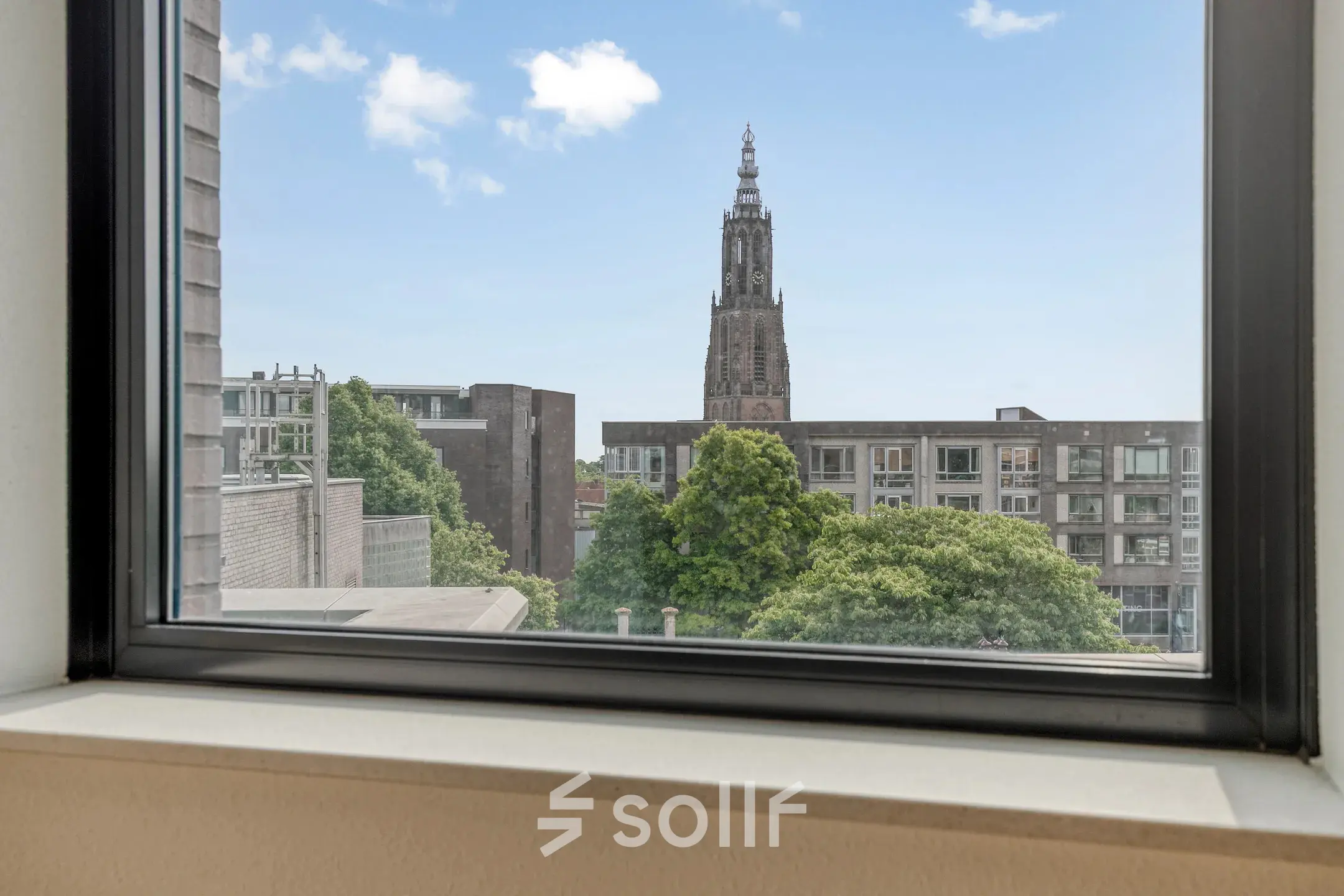 View from a window at an office space rental in Amersfoort Centrum, showcasing cityscape and greenery.