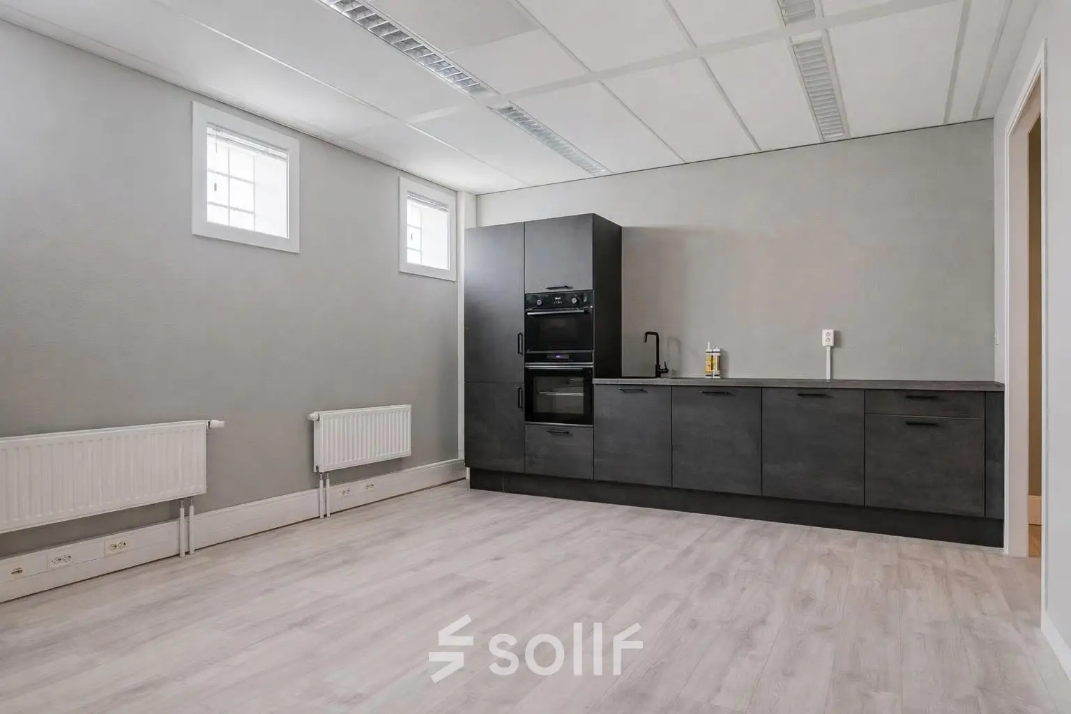 Unfurnished office space for rent in Amersfoort Centrum with modern built-in kitchen and ample natural light.