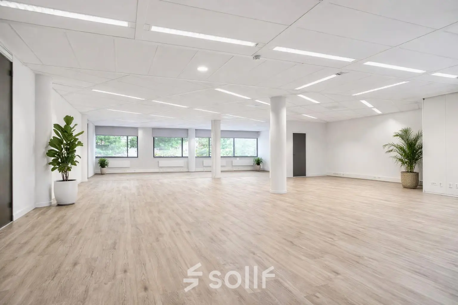 Spacious, unfurnished office space for rent at Asch van Wijckstraat 2-4 in Amersfoort Centrum, featuring large windows and wooden flooring.