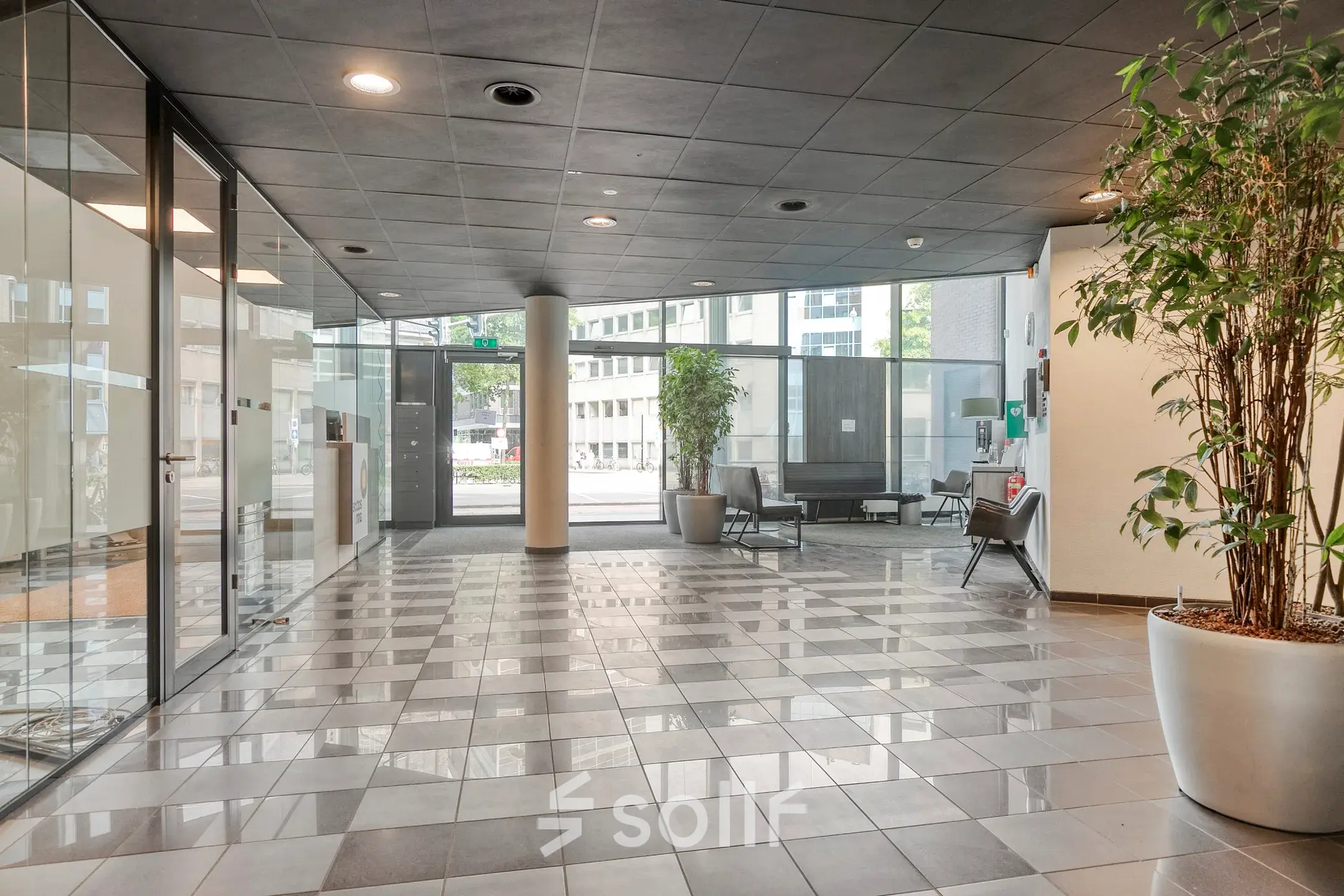 Spacious reception area at Asch van Wijckstraat 2-4, perfect for office space rental, with seating and greenery.