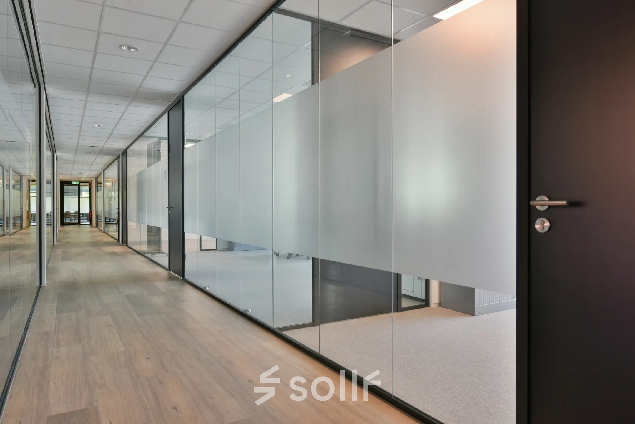 Modern hallway at office space rental in Amstelveen with glass doors and light wood flooring at De Gondel 1.
