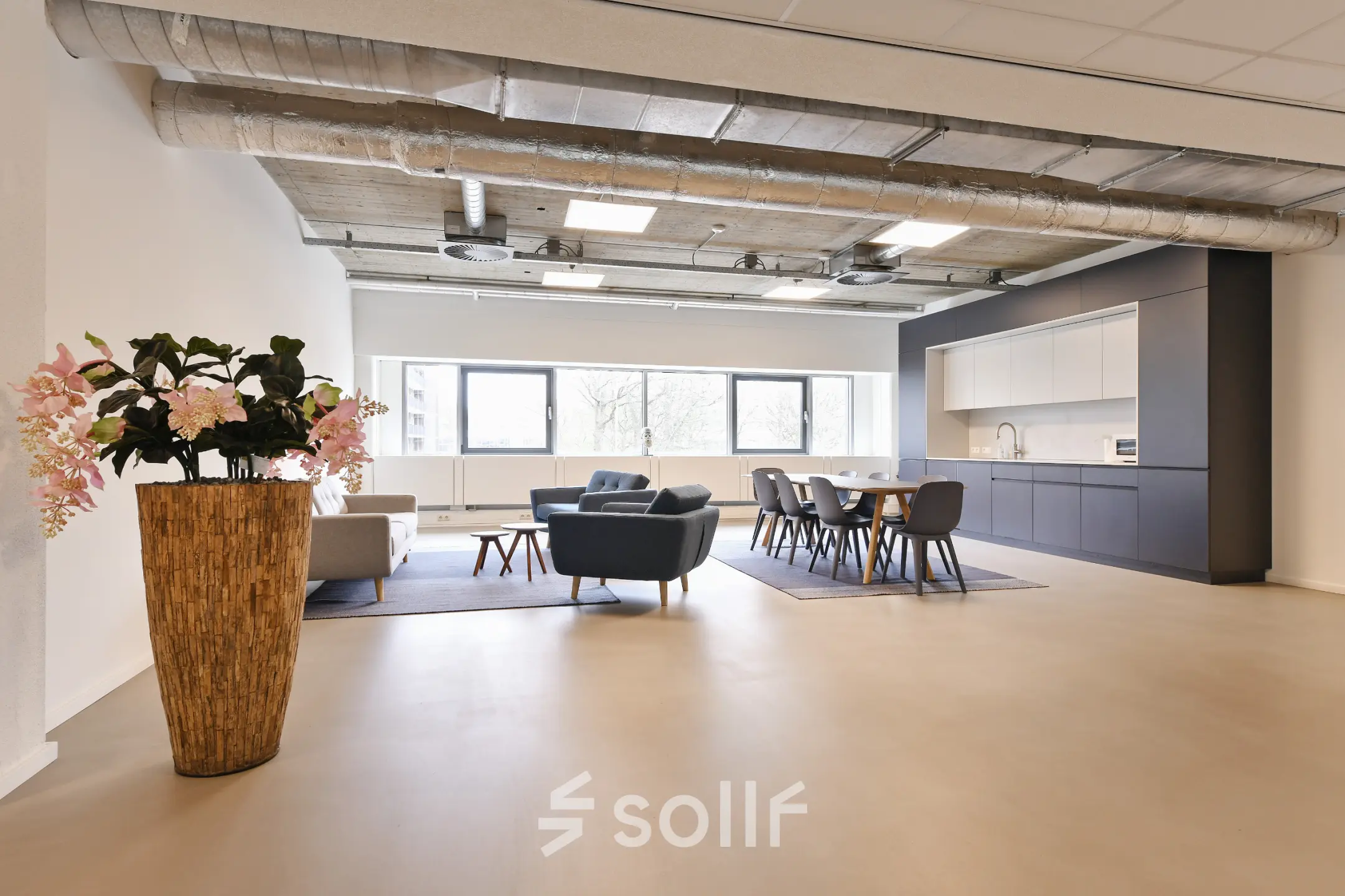 Amstelveen office to rent featuring a spacious, furnished open-floor layout with modern seating and kitchen area at Stroombaan 4.