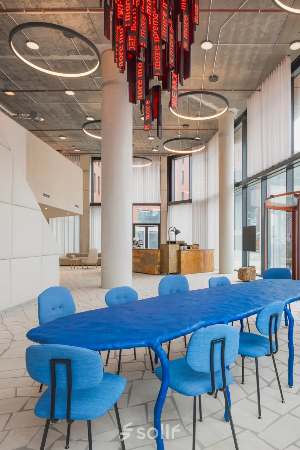 Large, modern workspace in H.J.E. Wenckebachweg 230-258, Amsterdam Amstel Business Park, featuring a unique blue table, comfortable chairs, and eye-catching decor. Ideal for office space rental.