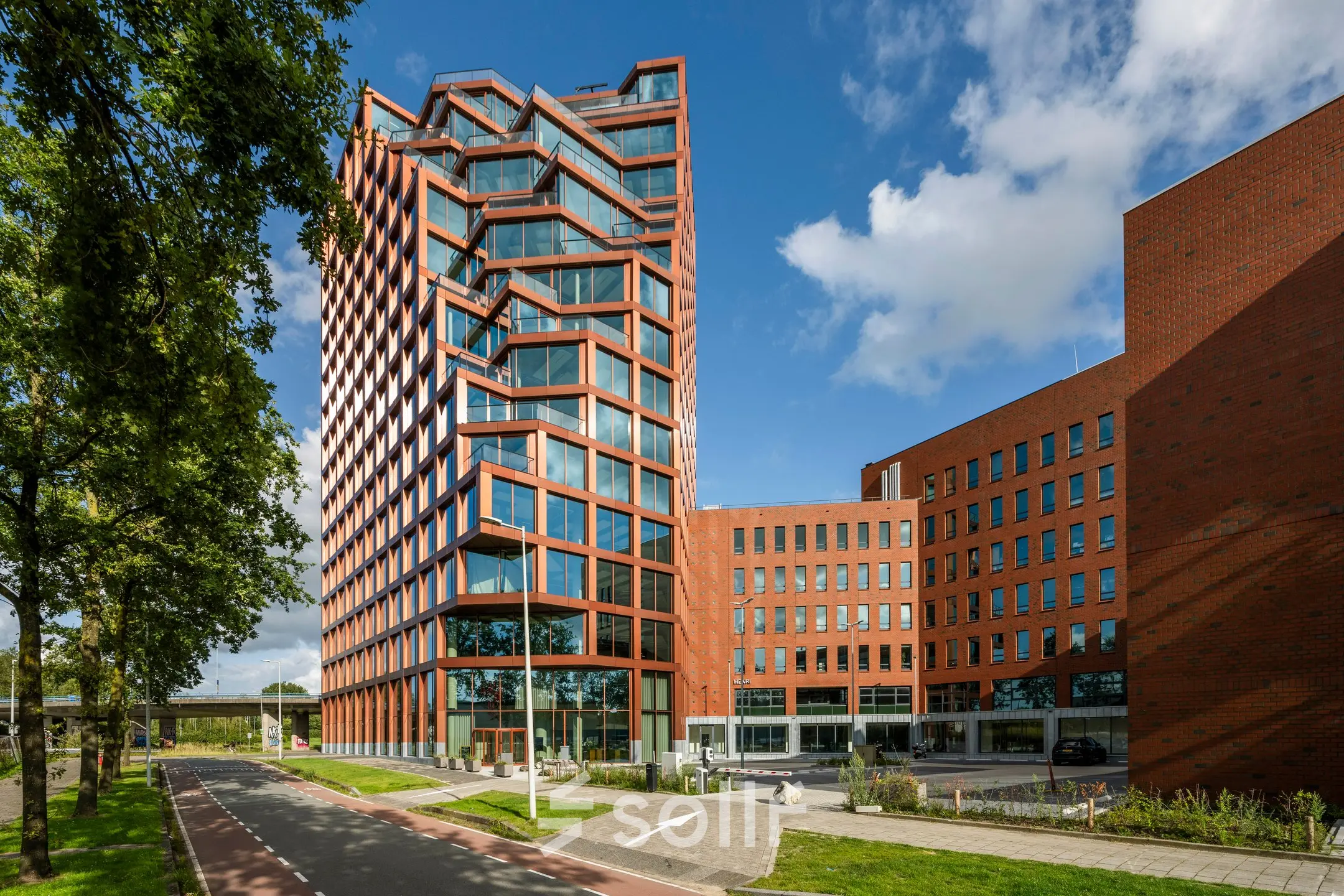 Modern office building with red brick and glass facade located at H.J.E. Wenckebachweg 230-258, Amsterdam Amstel Business Park. Ideal for office space rental.