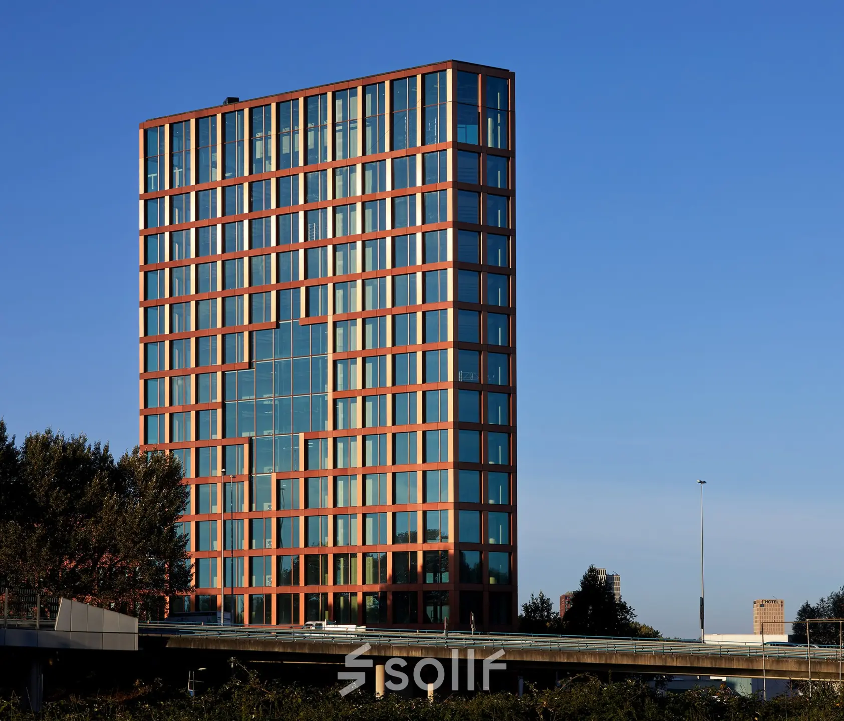 Exterior view of a modern office building at H.J.E. Wenckebachweg 230-258, Amsterdam Amstel Business Park, featuring reflective glass and structured facade, ideal for office space rental.
