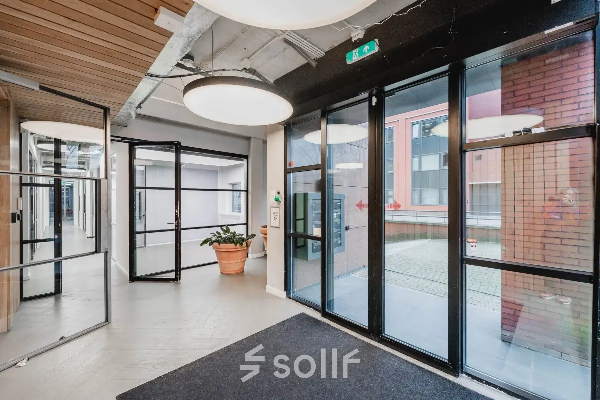 Modern office entrance at H.J.E. Wenckebachweg 90-108, Amsterdam Amstel Business Park, featuring glass doors and a stylish interior ideal for office space rental.