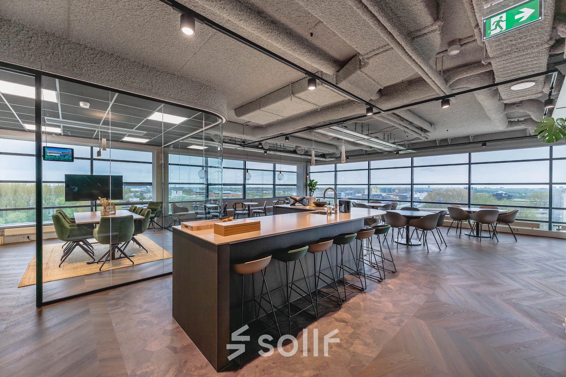 Bright, modern office space for rent at Joop Geesinkweg 201, located in Amsterdam Amstel Business Park, featuring a bar-style seating area and a conference room.