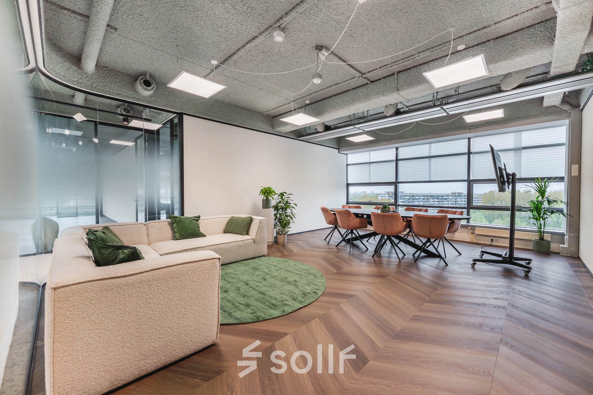 Modern furnished office space for rent at Amsterdam Amstel Business Park, featuring a meeting area with a table, chairs, and a seating section near the window at Joop Geesinkweg 201.