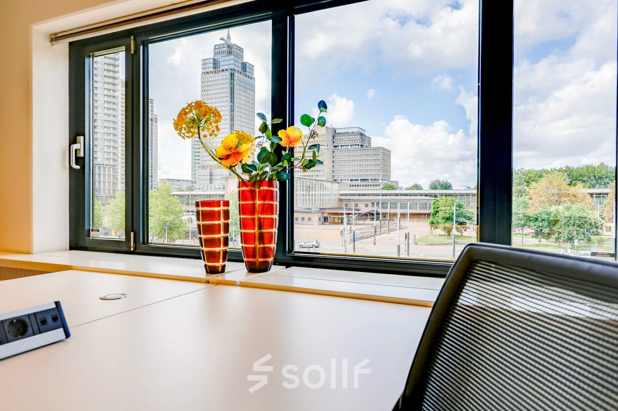 Bright office space at Prins Bernhardplein 200, Amsterdam Amstel, featuring a desk with chairs and a view of the cityscape.