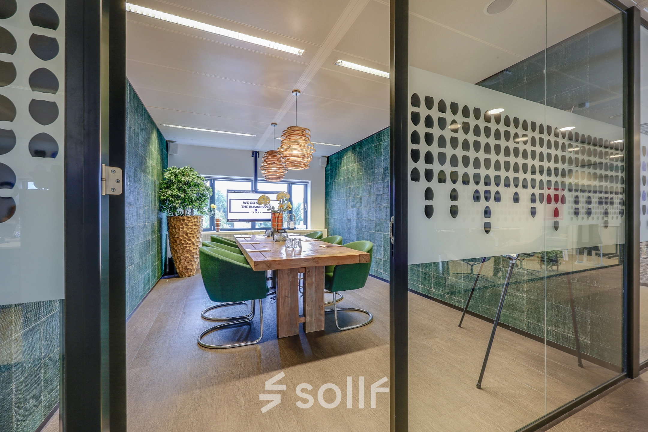 Modern furnished conference room at Prins Bernhardplein 200, Amsterdam Amstel, featuring a wooden table and green chairs, ideal for office space rental.