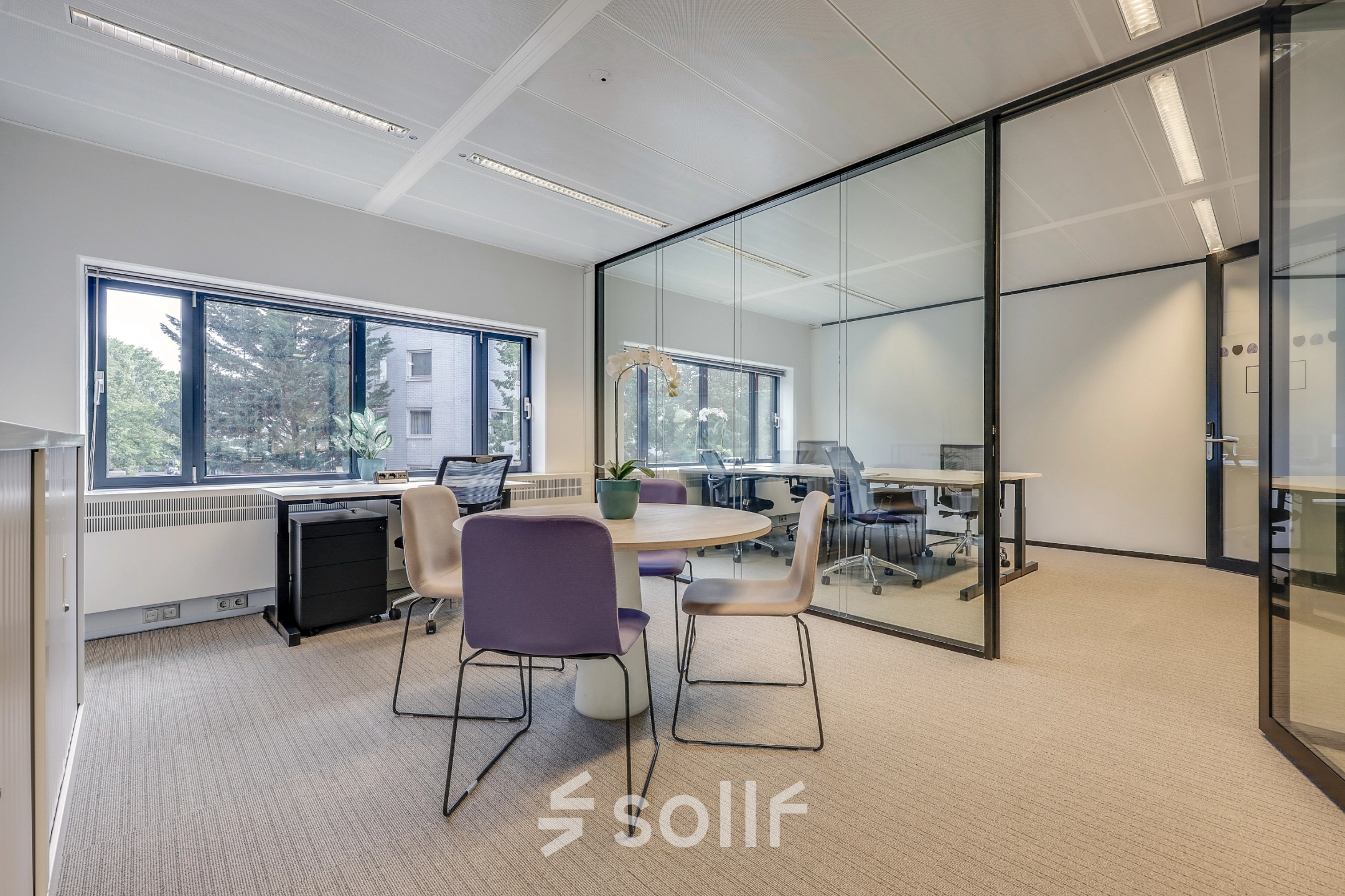 Modern office space at Prins Bernhardplein 200 in Amsterdam Amstel, featuring glass walls, desks, and seating. Ideal for office space rental with natural light.