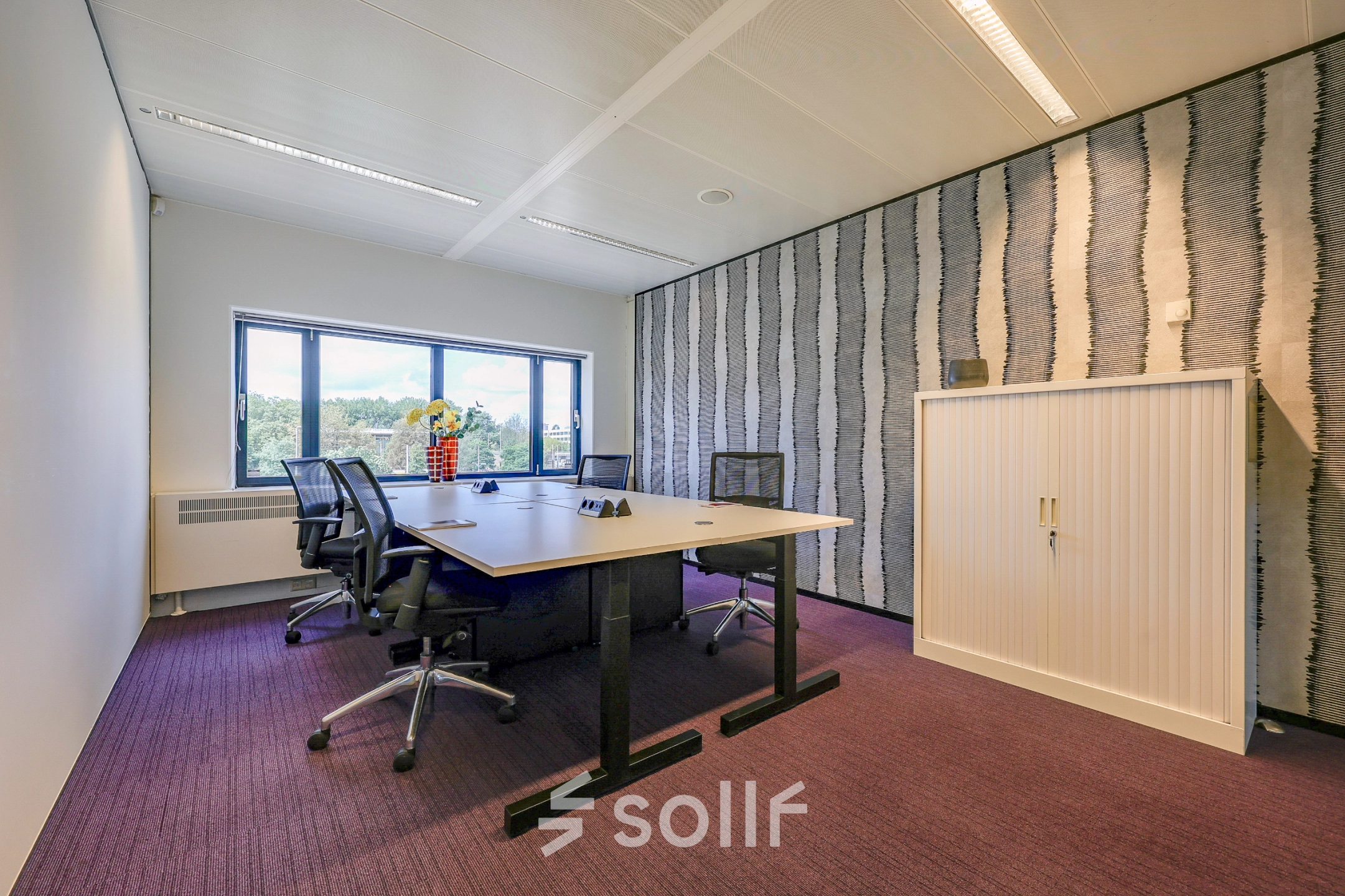 Furnished office space for rent at Prins Bernhardplein 200, Amsterdam Amstel, featuring a table, chairs, and a view of the outdoors.