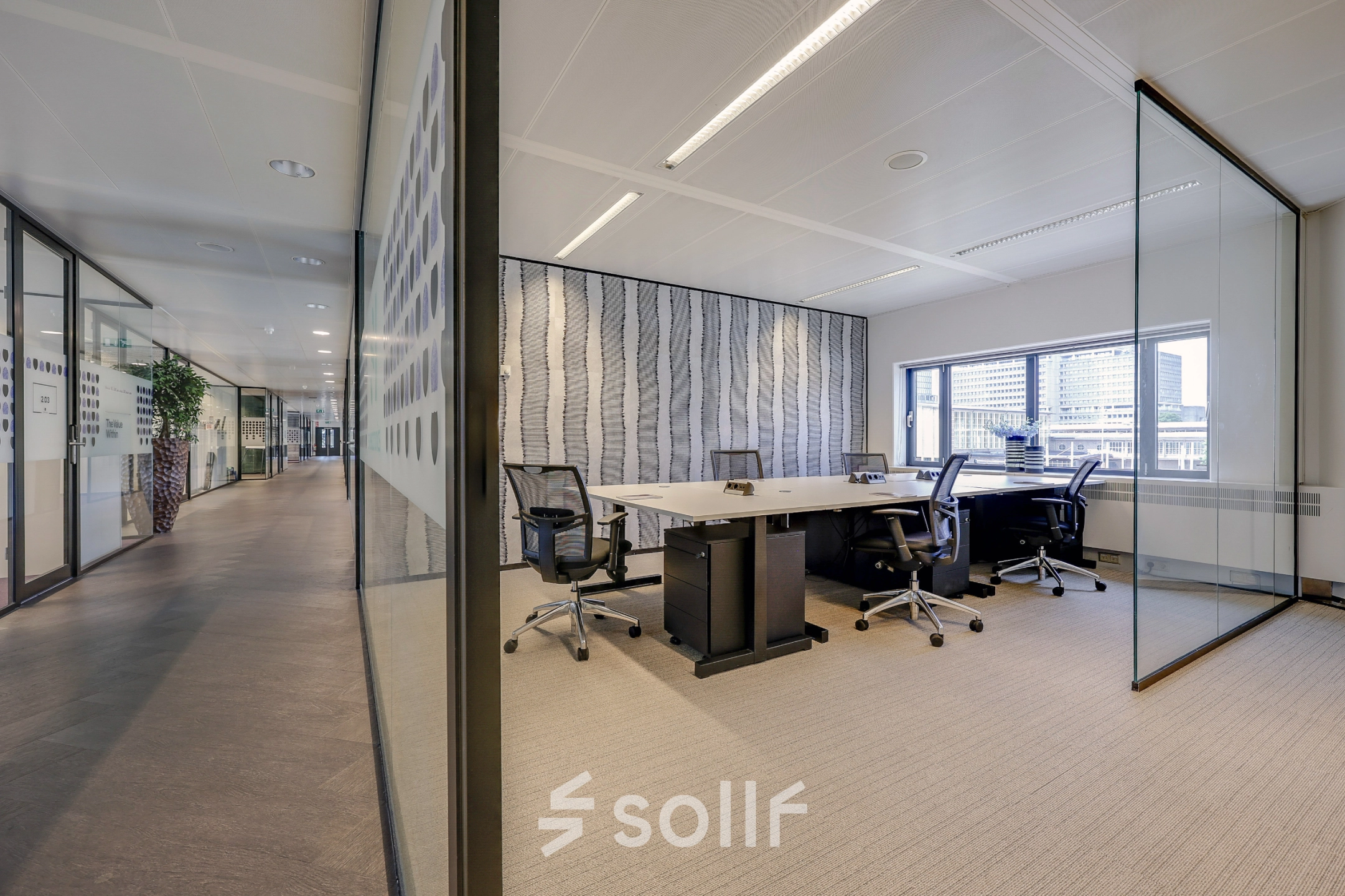 Modern office space with glass partitions at Prins Bernhardplein 200, Amsterdam Amstel, ideal for office space rental. Bright workspace with chairs and desks offering plenty of natural light.