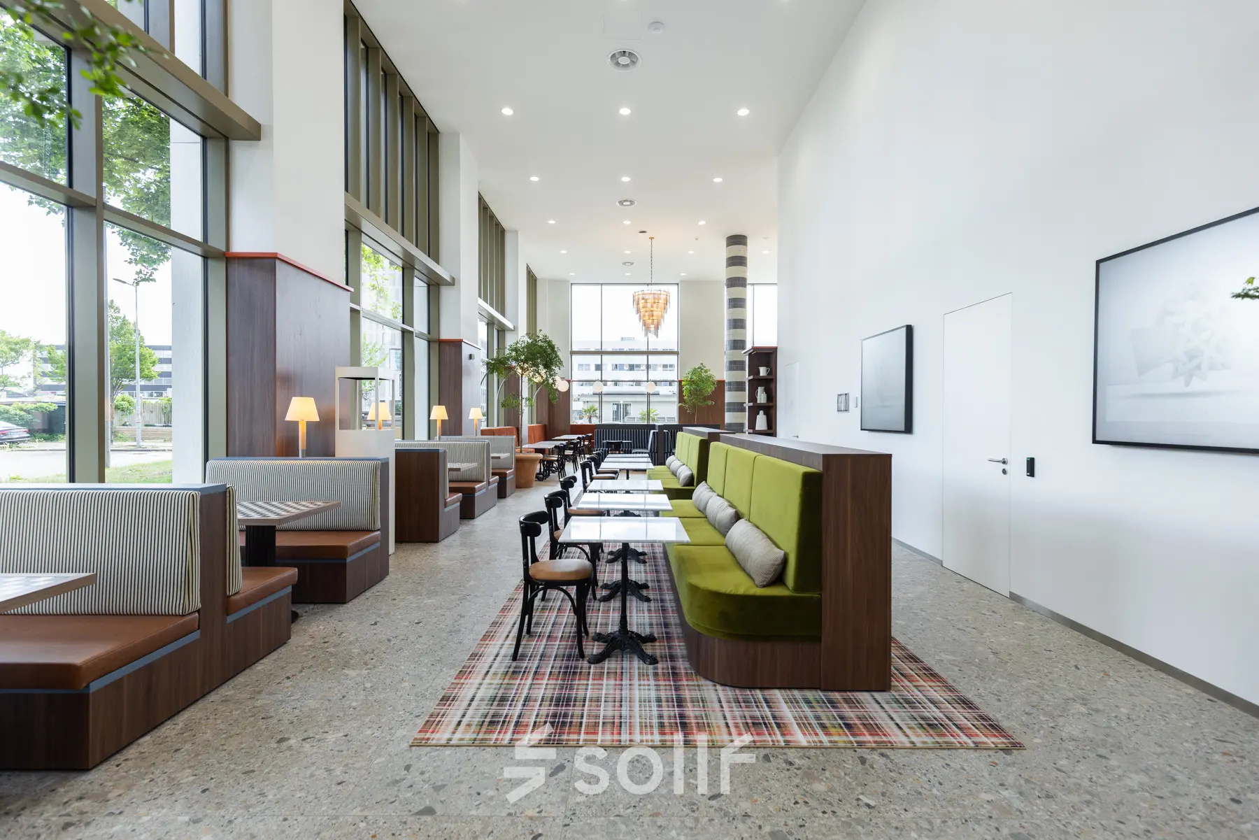 Modern office space with stylish booths and tables, featuring large windows and a minimalist design at Willem Fenengastraat 16, Amsterdam Amstel. Ideal for office space rental.