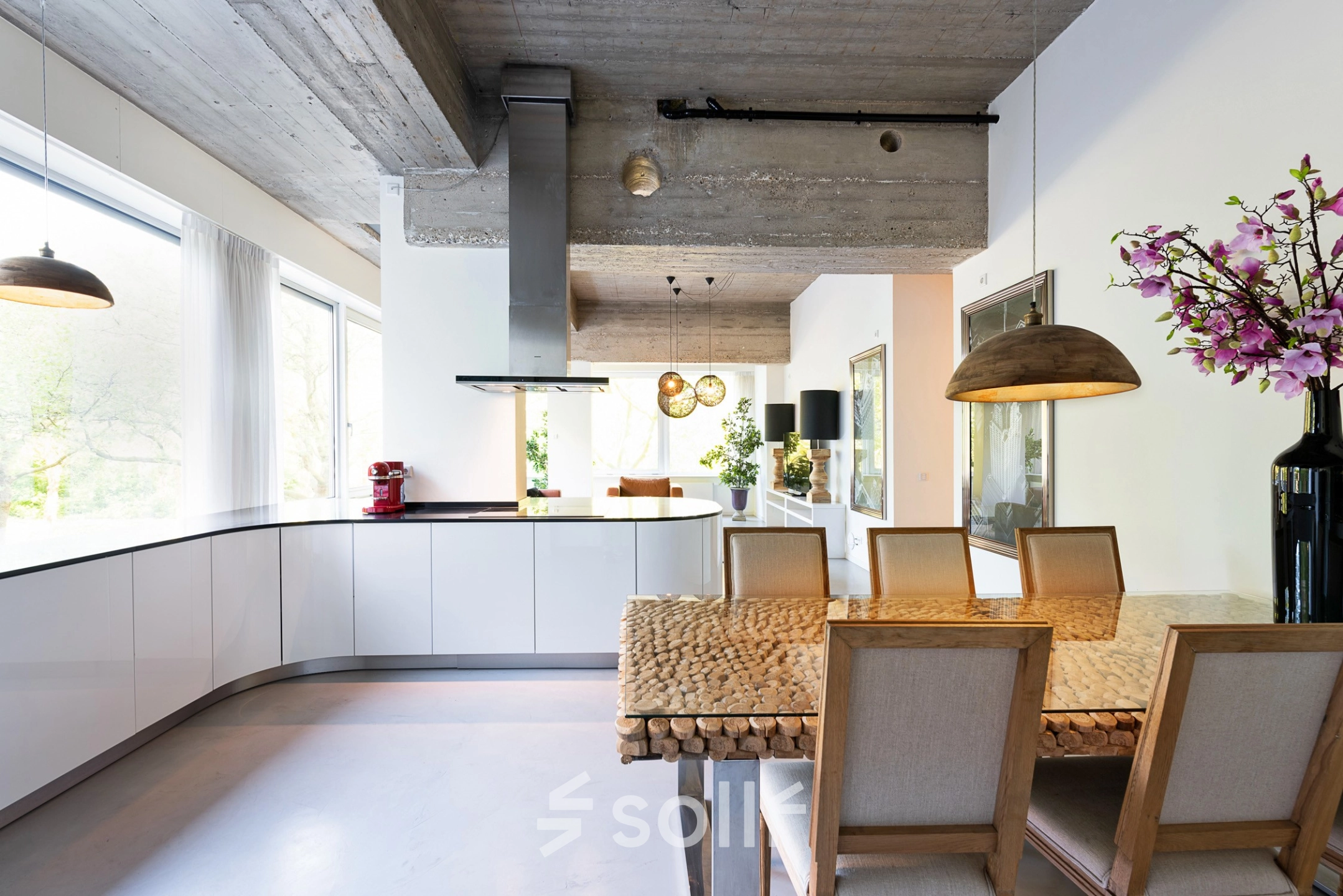 Bright and modern workspace featuring a sleek kitchen setup with wooden dining table, stylish lighting, and large windows at Teilingen 1, Amsterdam Buitenveldert, ideal for office space rental.