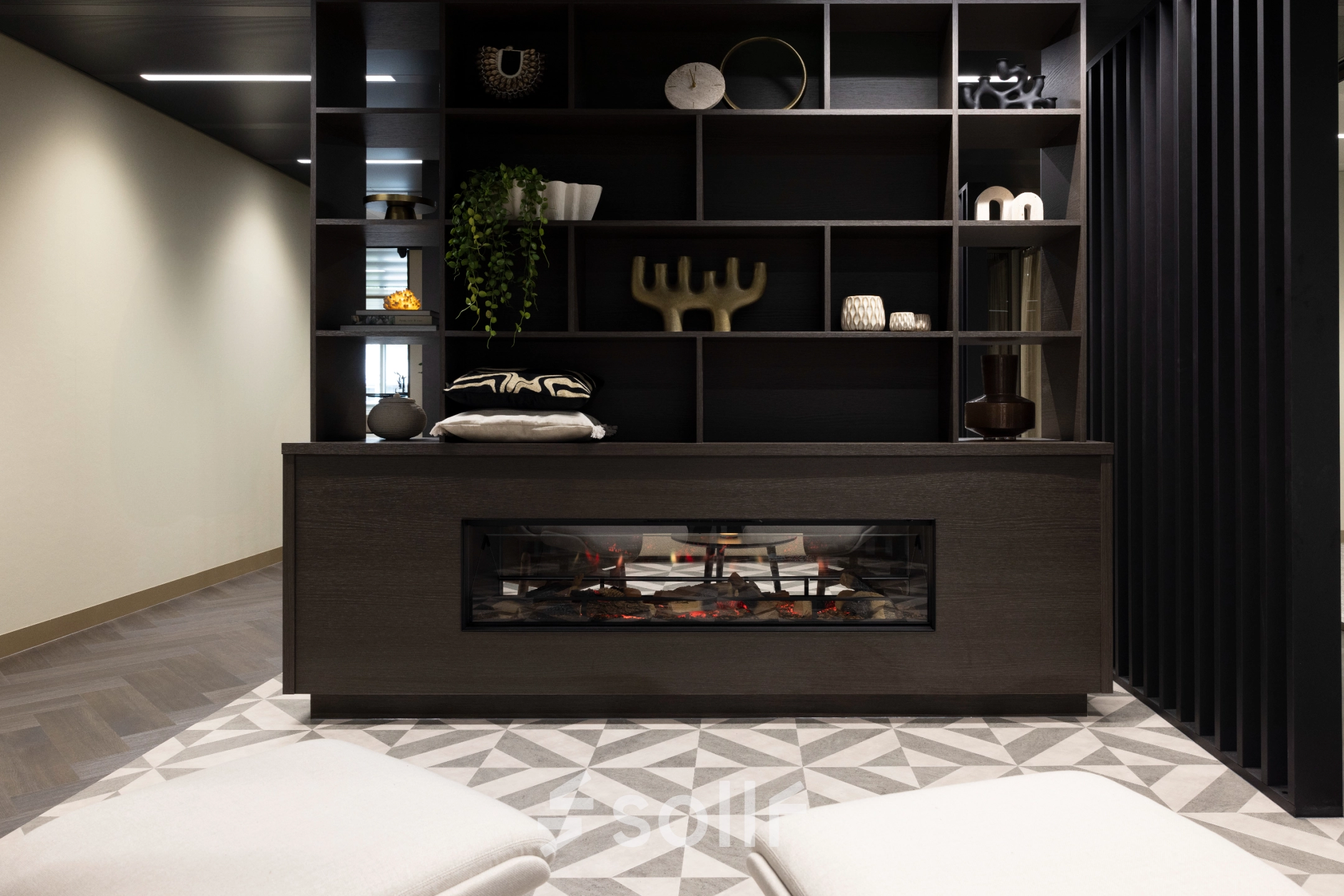 Stylish interior view of an office lounge at Walborg 2A, Amsterdam Buitenveldert, featuring modern decor with a decorative fireplace and shelving. Perfect for office space rental.
