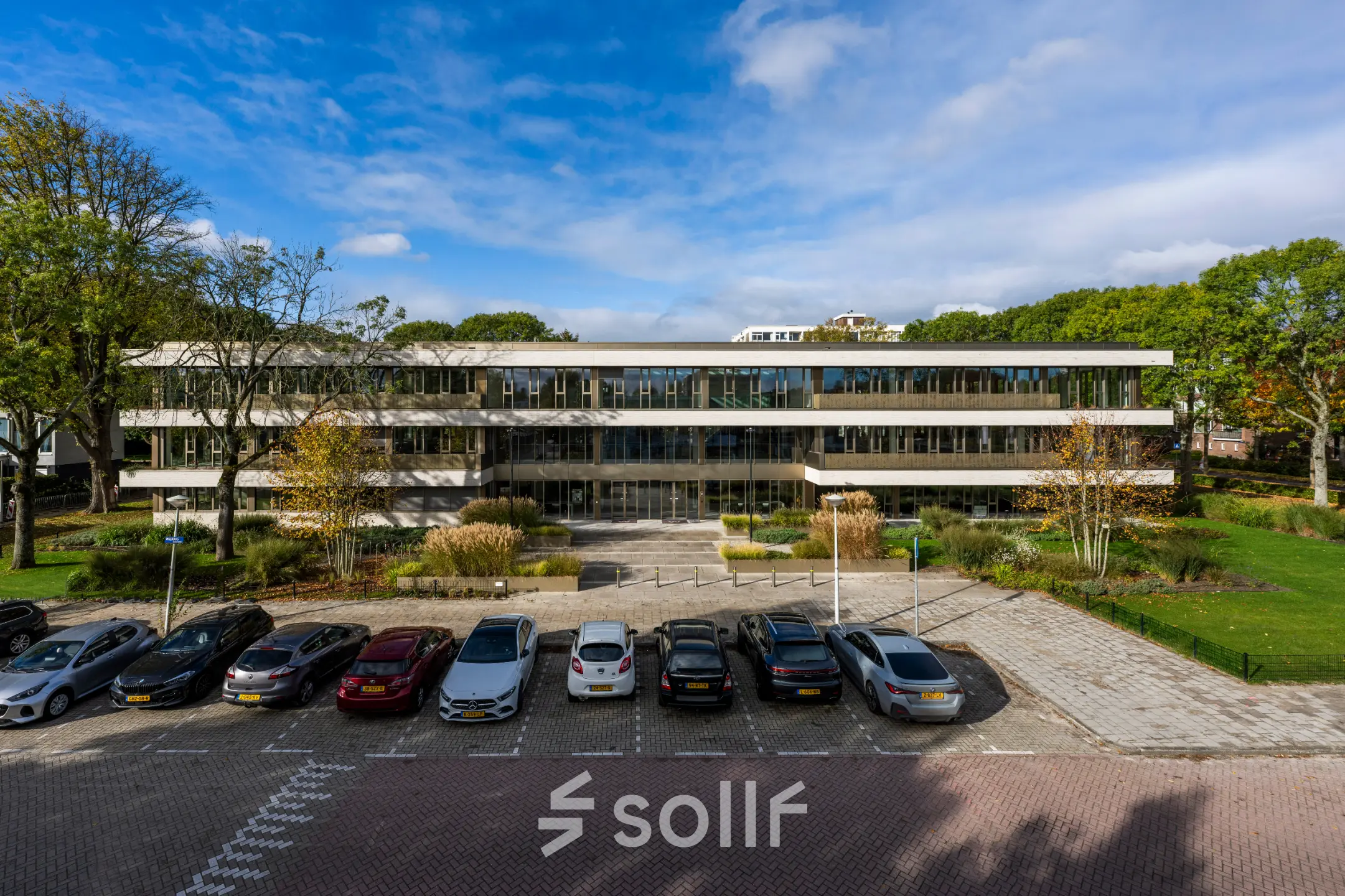Exterior view of the office building at Walborg 2A in Amsterdam Buitenveldert, featuring ample parking space and surrounded by greenery, ideal for office space rental.