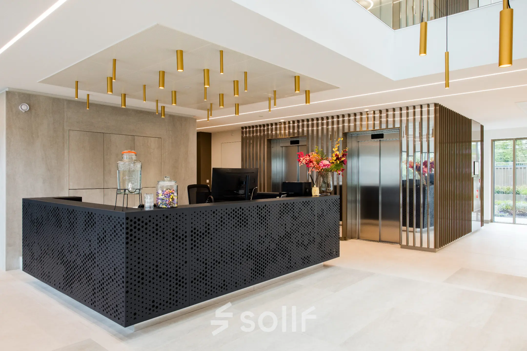 Modern reception area with sleek black desk and decorative lighting in an office space for rent at Walborg 2A, Amsterdam Buitenveldert.
