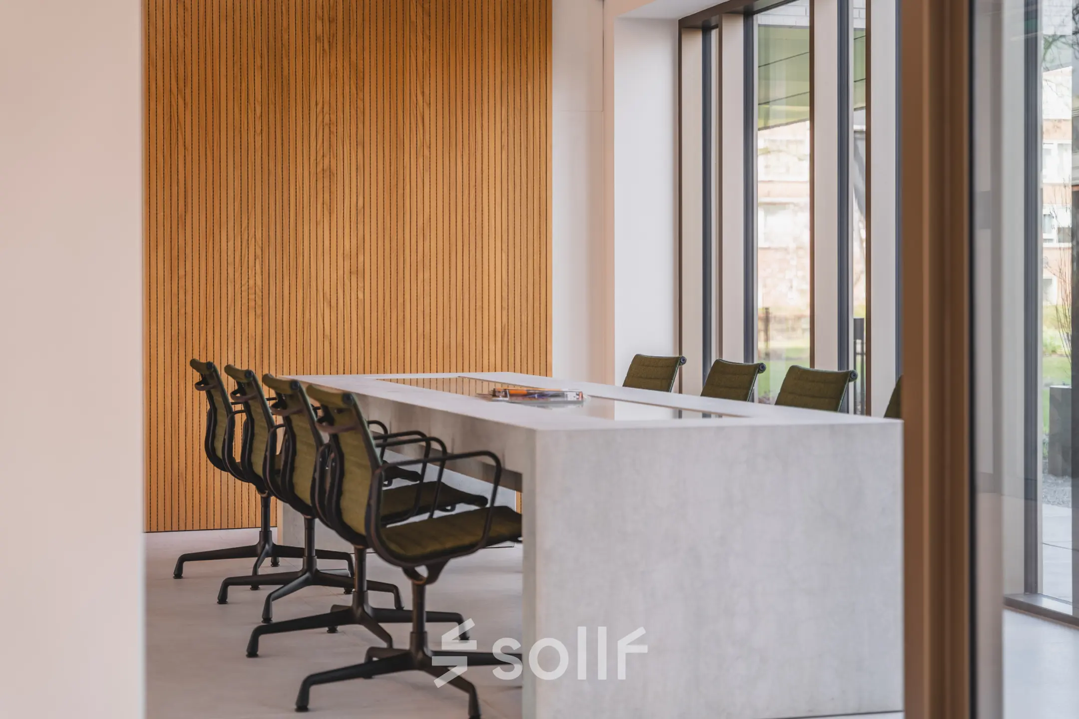 Stylish conference room available for office space rental at Walborg 2A, Amsterdam Buitenveldert, featuring a sleek table and comfortable chairs against a modern wooden accent wall.