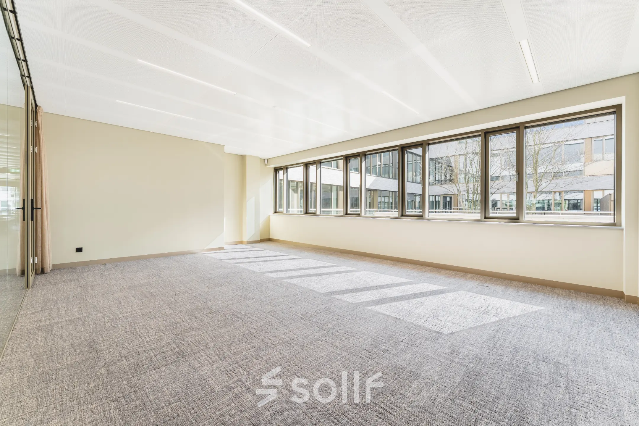 Bright, unfurnished office space available for rent at Walborg 2A, Amsterdam Buitenveldert, featuring large windows letting in natural light.