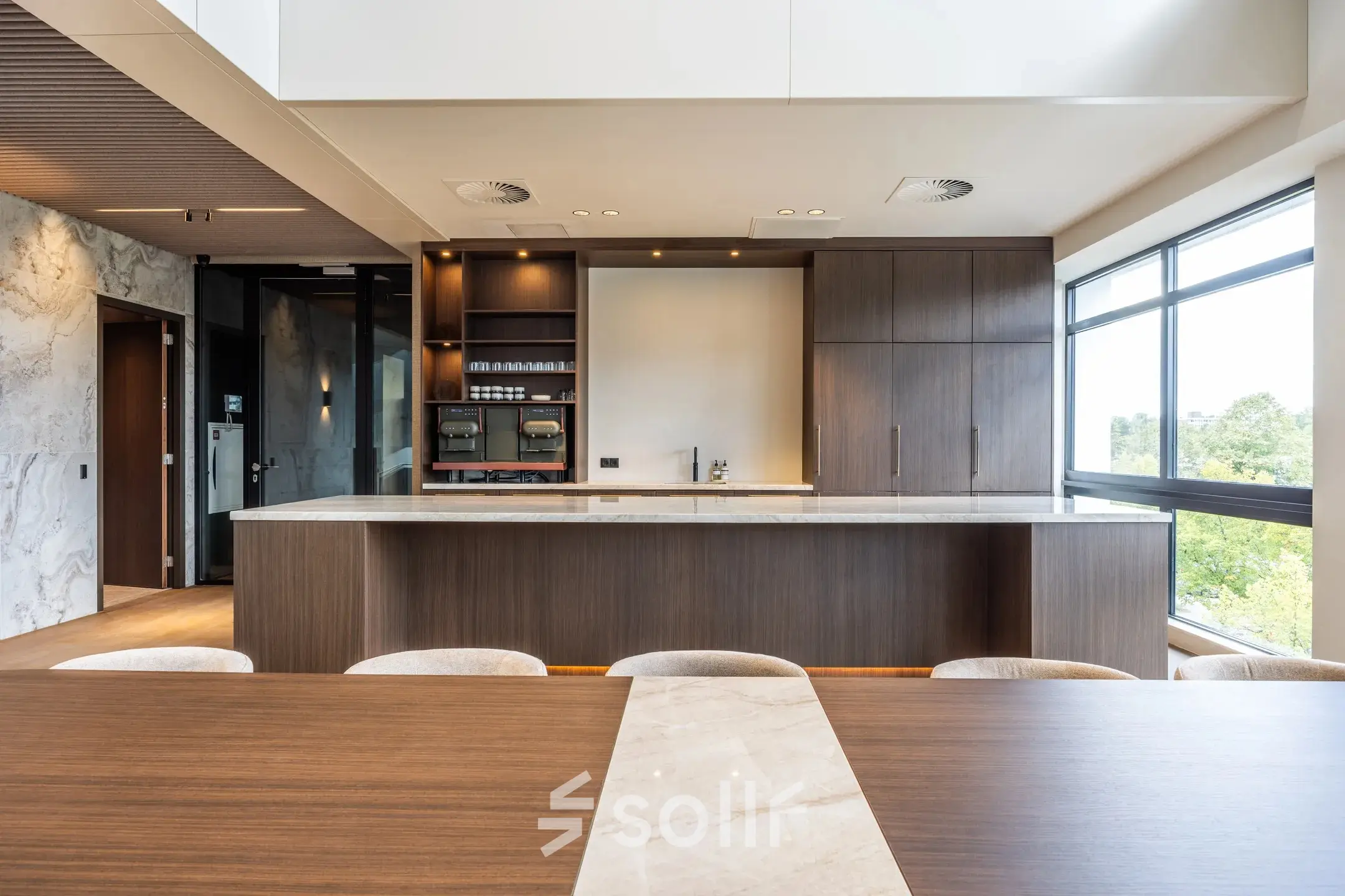 Furnished office space available for rent at Zwaansvliet 1 in Amsterdam Buitenveldert, featuring a modern interior with wooden finishes and ample natural light through large windows.