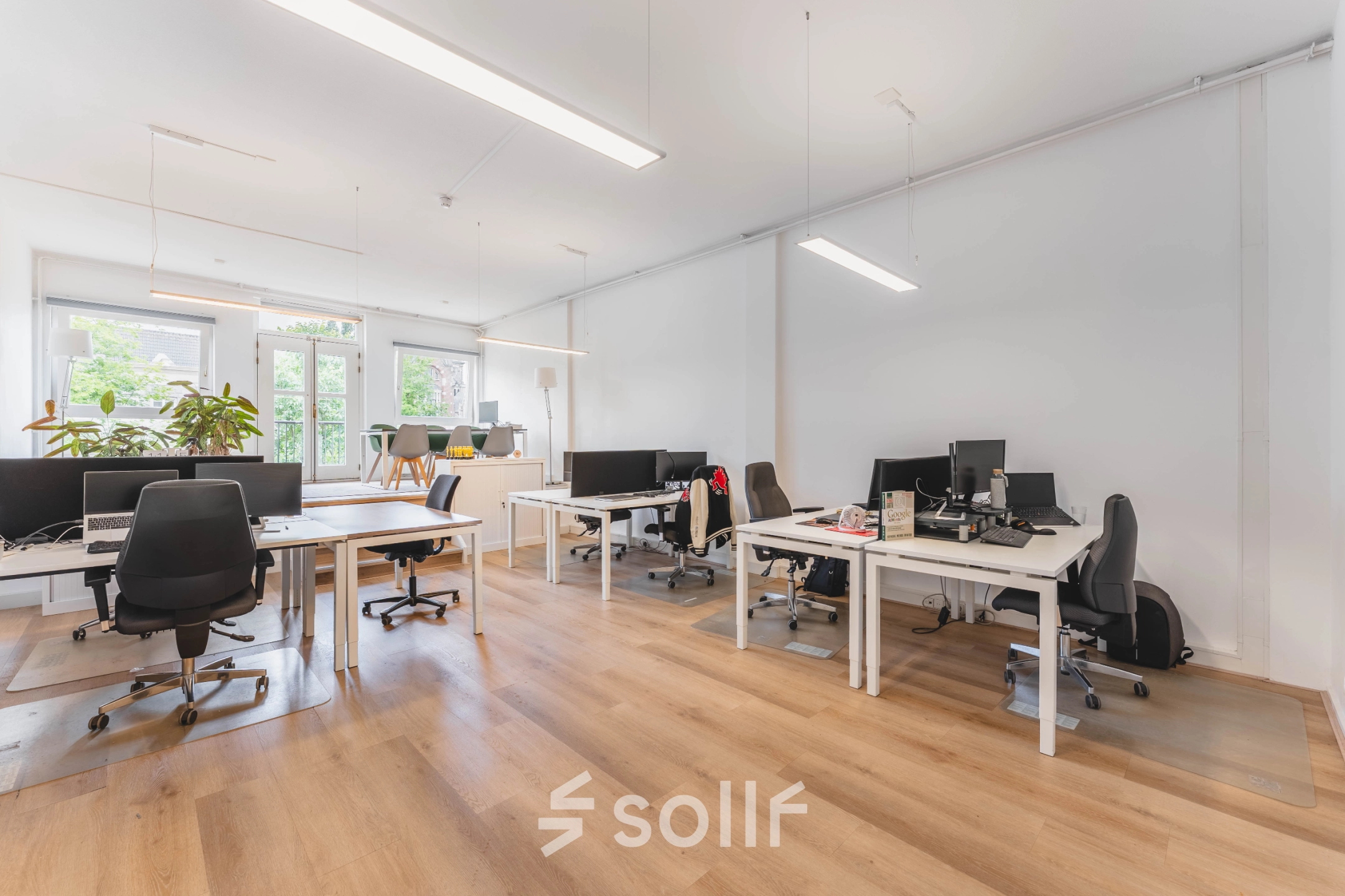 Bright, furnished office space at Herengracht 221 in Amsterdam Canal Belt features multiple workstations and large windows for natural light, ideal for office space rental.