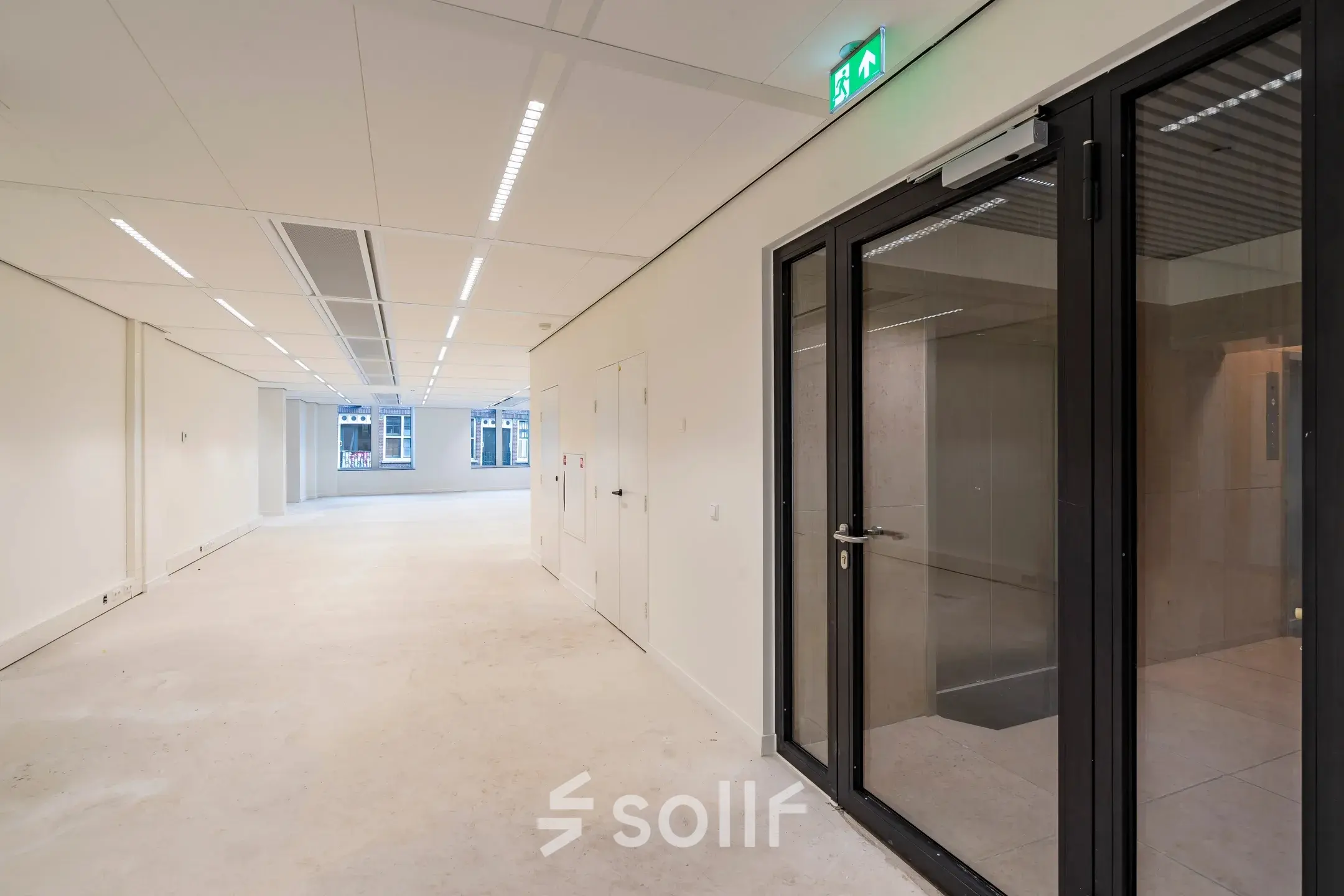 Empty office space available for rent at Herengracht 459-469, Amsterdam Canal Belt, featuring large windows and modern lighting.