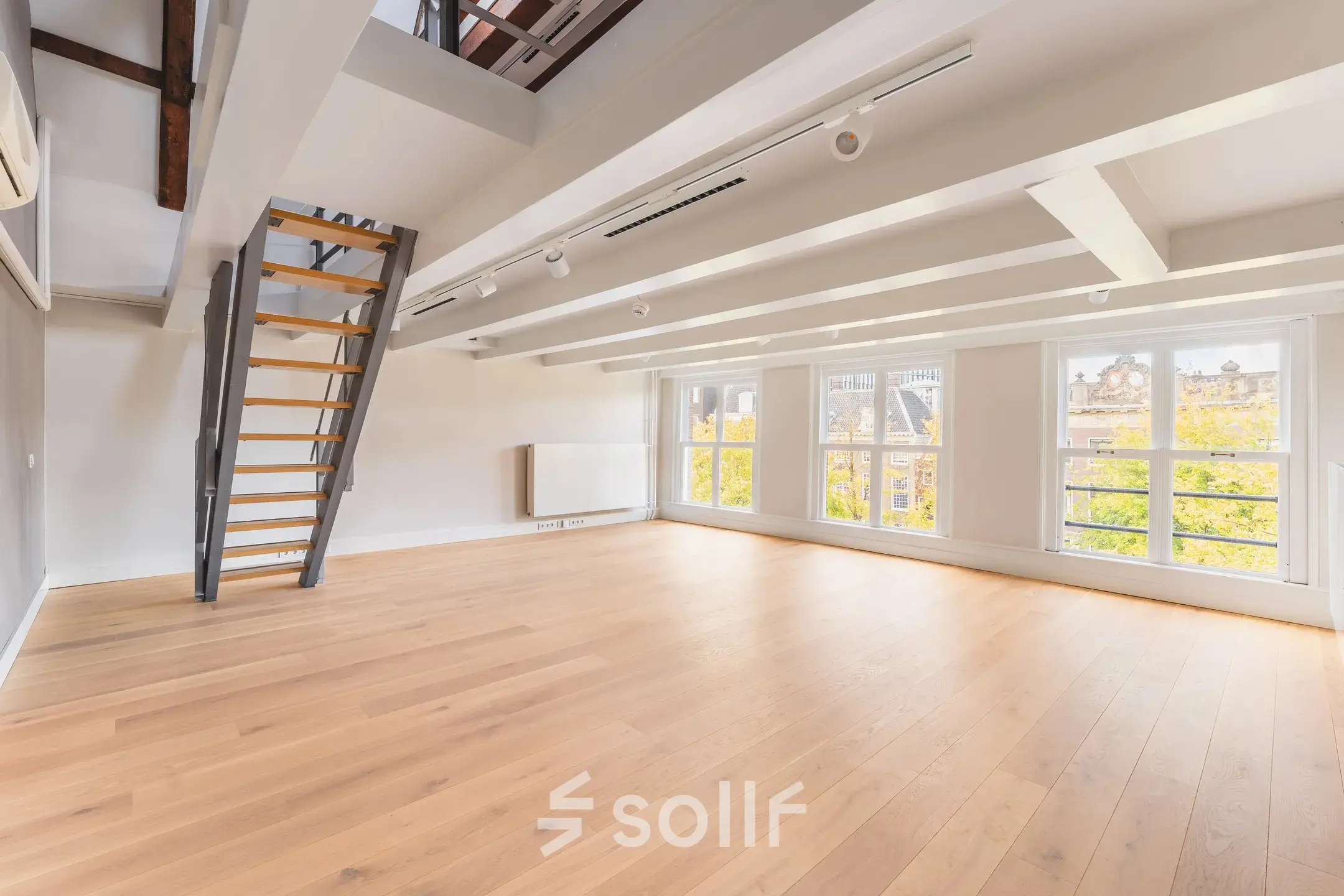 Spacious unfurnished office interior with wooden flooring and large windows at Herengracht 582-584, Amsterdam Canal Belt. Ideal for office space rental.