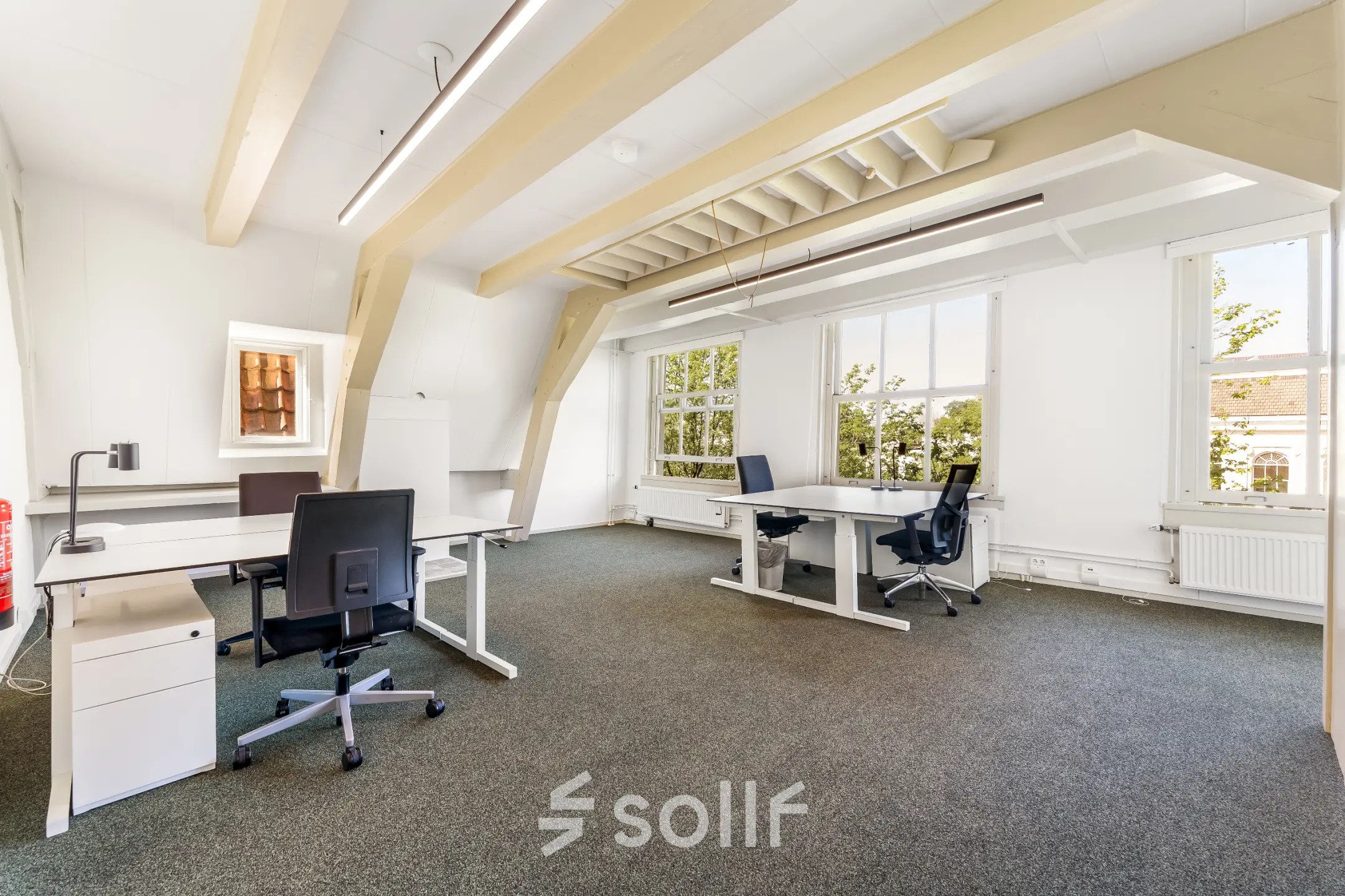 Bright office space rental at Keizersgracht 261, Amsterdam Canal Belt, featuring desks and chairs with natural light pouring in.