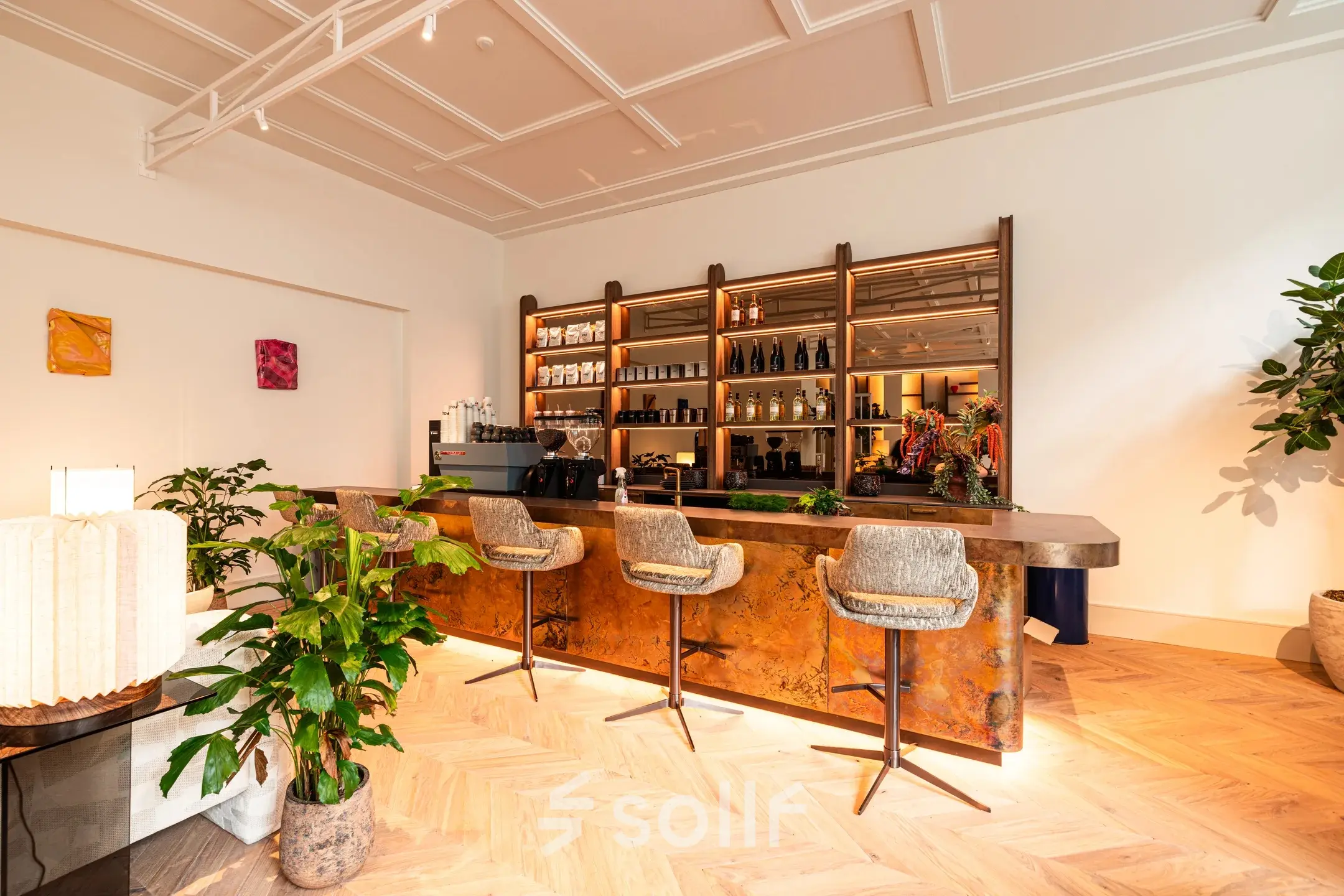 Elegant workspace at Keizersgracht 264, Amsterdam Canal Belt, featuring a stylish bar area with seating and decorative plants, ideal for office space rental.