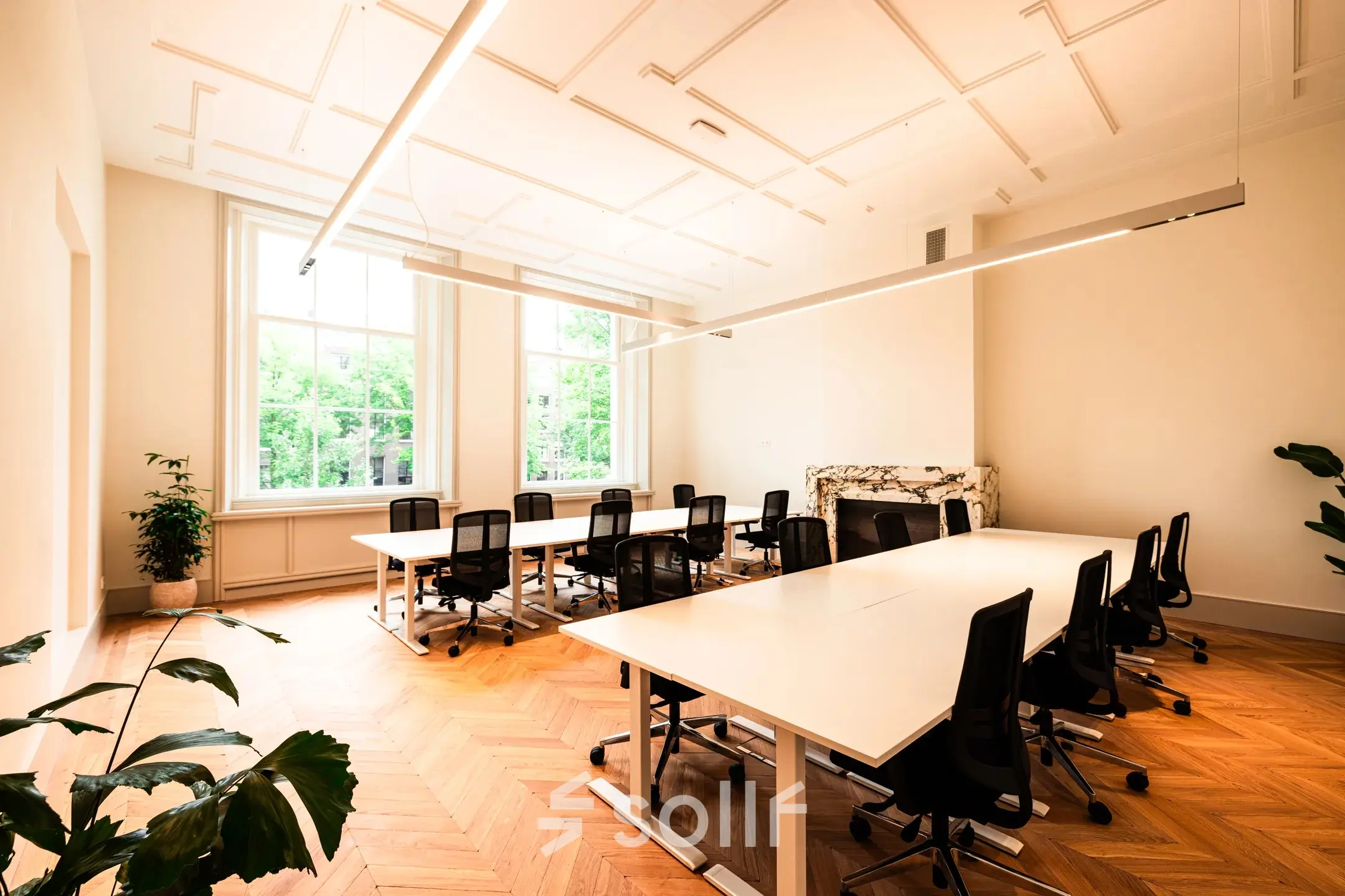 Furnished office space with desks and chairs ideal for rent at Keizersgracht 264, offering a bright workspace with large windows in Amsterdam Canal Belt.