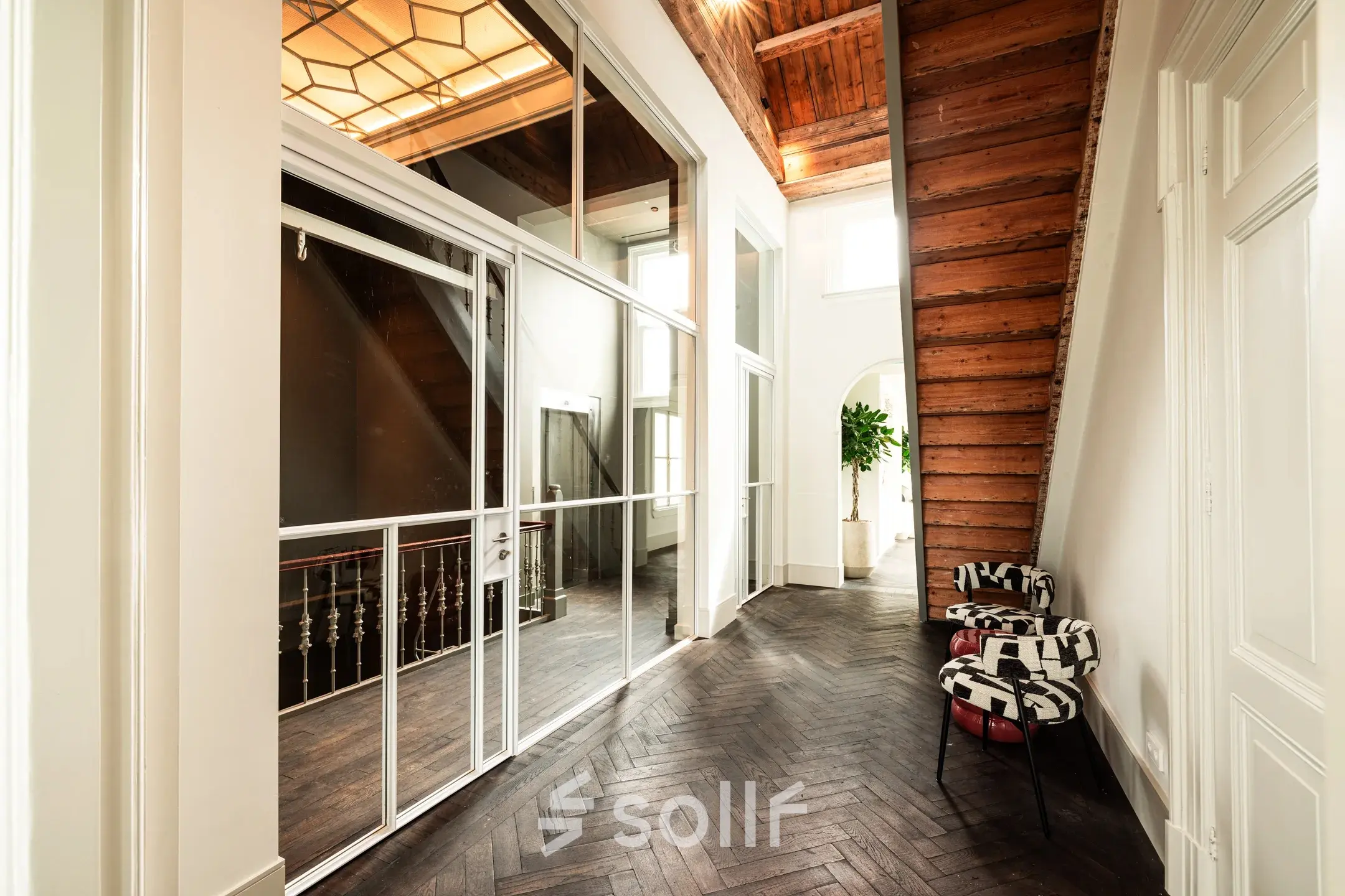 Spacious hallway with wooden floors and modern glass panels at Keizersgracht 264, ideal for businesses seeking office space rental in Amsterdam Canal Belt.