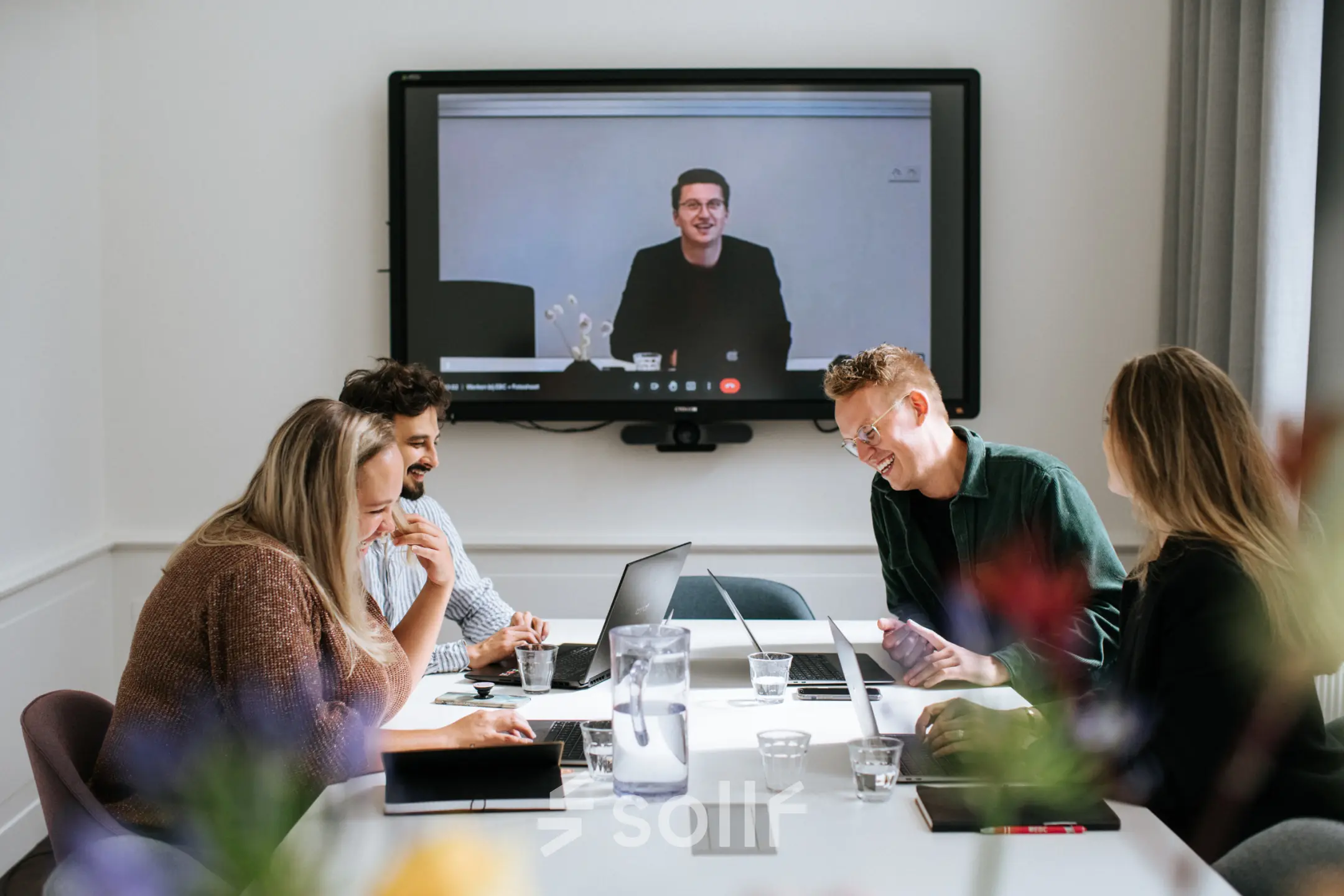 A vibrant office space in Amsterdam's Canal Belt at Keizersgracht 62-64, where professionals engage in a lively video conference, exemplifying an ideal office space rental.
