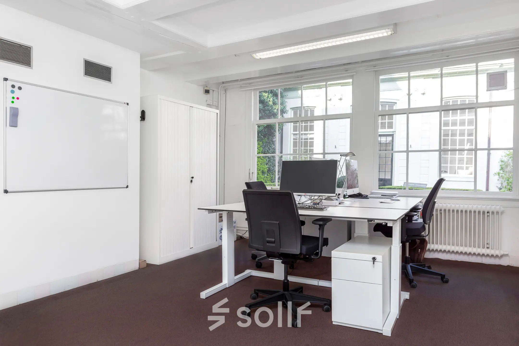 Bright office space with large windows, furnished with desks and chairs, ideal for office space rental at Keizersgracht 62-64 in Amsterdam Canal Belt.