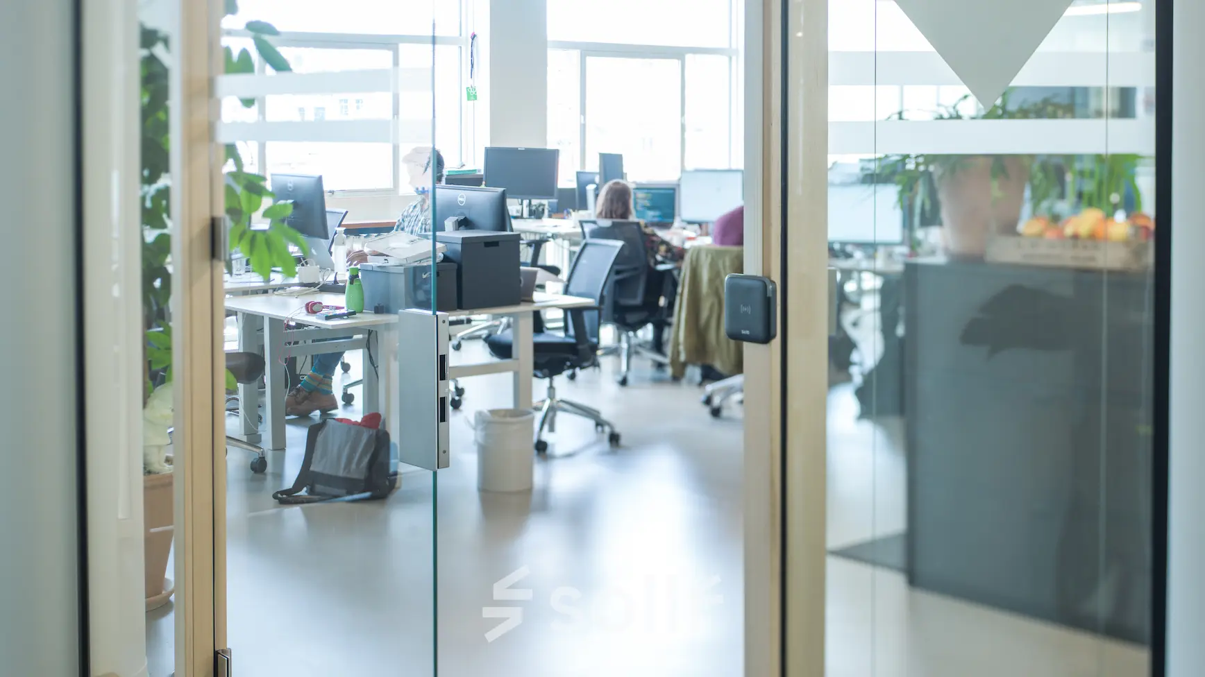 Modern office space at Singel 542, Amsterdam Canal Belt with people collaborating at workstations, available for office space rental.