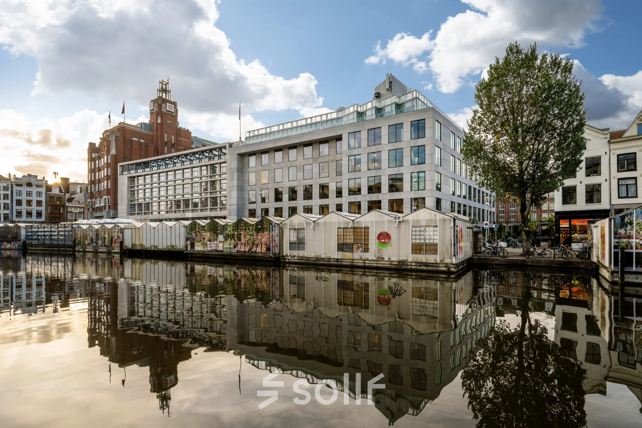 Exterior view of an office building at Singel 542, in Amsterdam Canal Belt, reflecting in the canal, ideal for rent office space seekers.