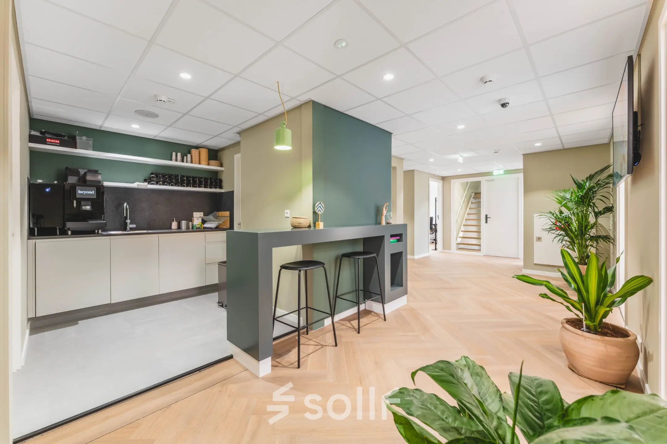 Modern office space rental at Herengracht 471, Amsterdam Center with a sleek kitchenette and seating area, suitable for those seeking an office to rent in a professional setting.