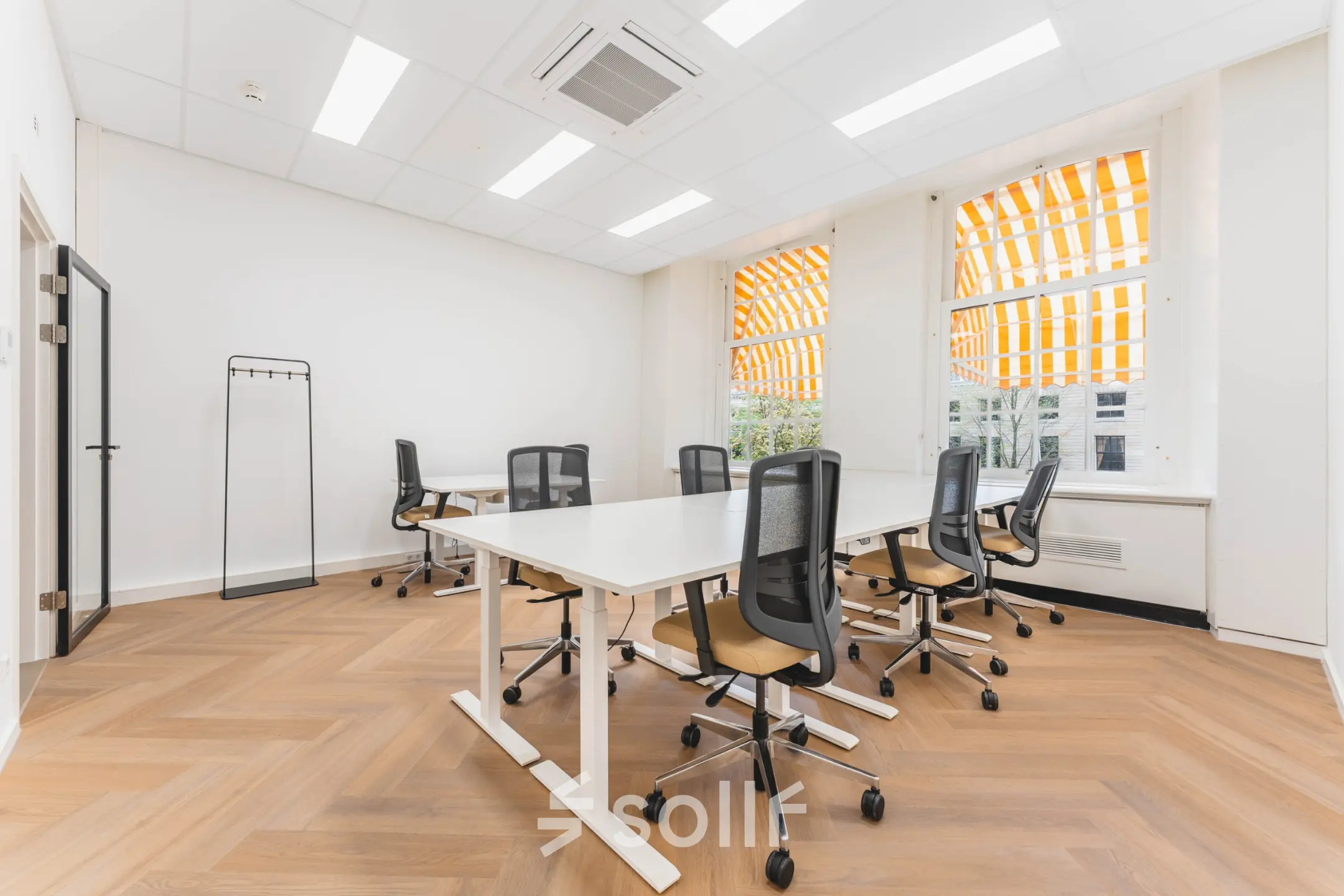 Bright office with modern desks and chairs at Herengracht 471, Amsterdam Center, ideal for office space rental.