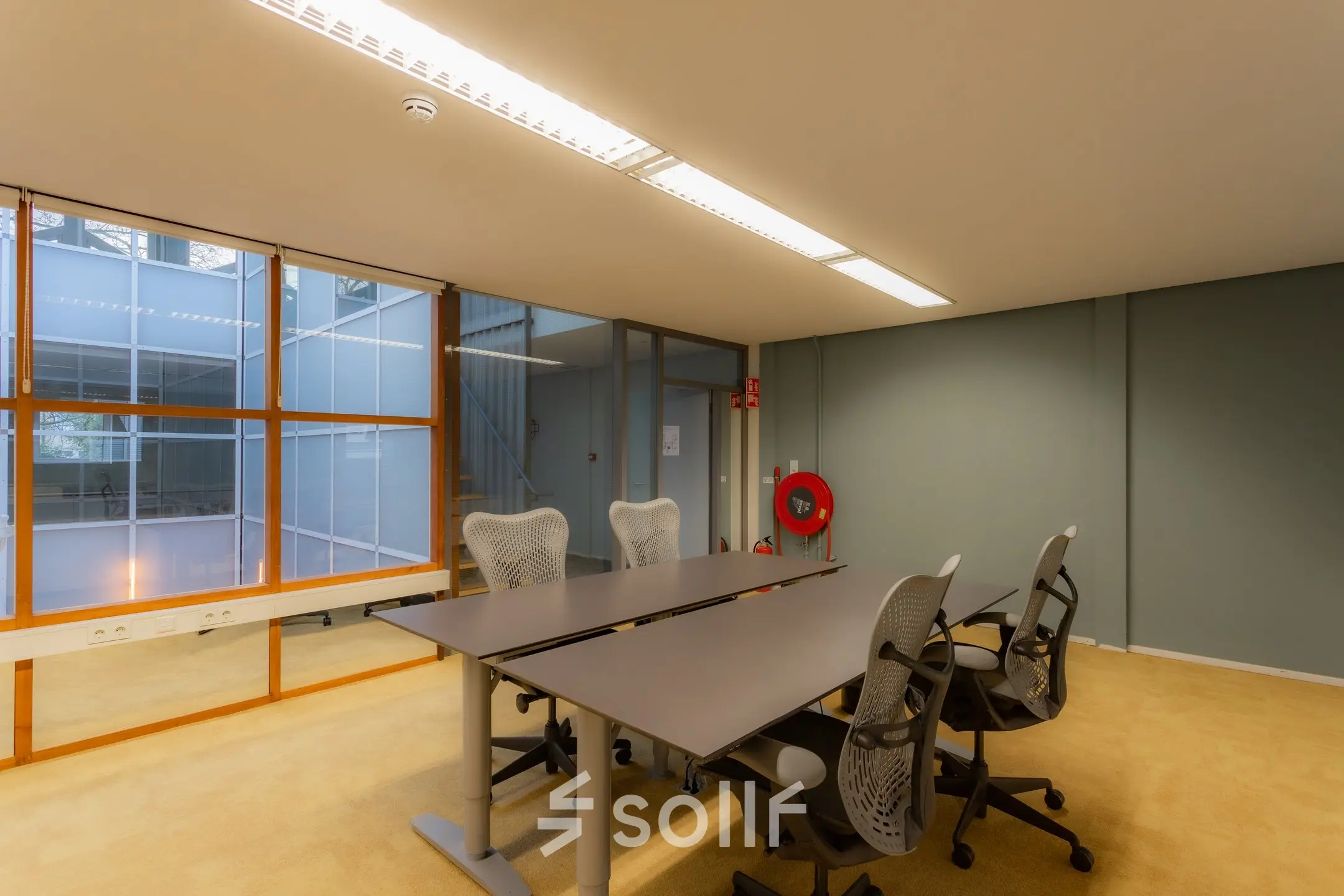 Quiet office space with large windows and modern chairs, perfect for office space rental at Kerkstraat 204, Amsterdam Center.