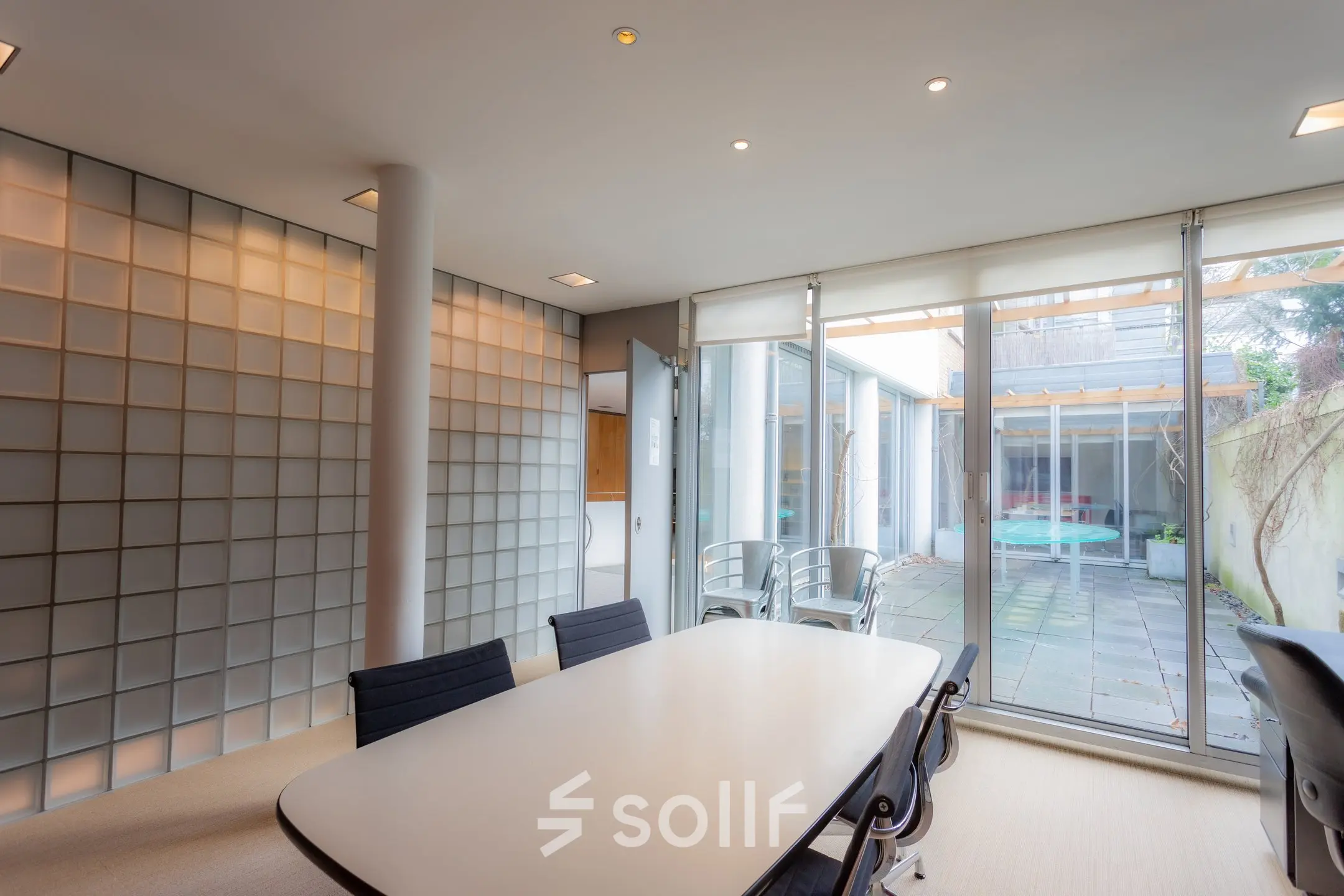 Bright office space in Amsterdam Center with a table and chairs, ideal for meetings or conferences. Large windows provide natural light.