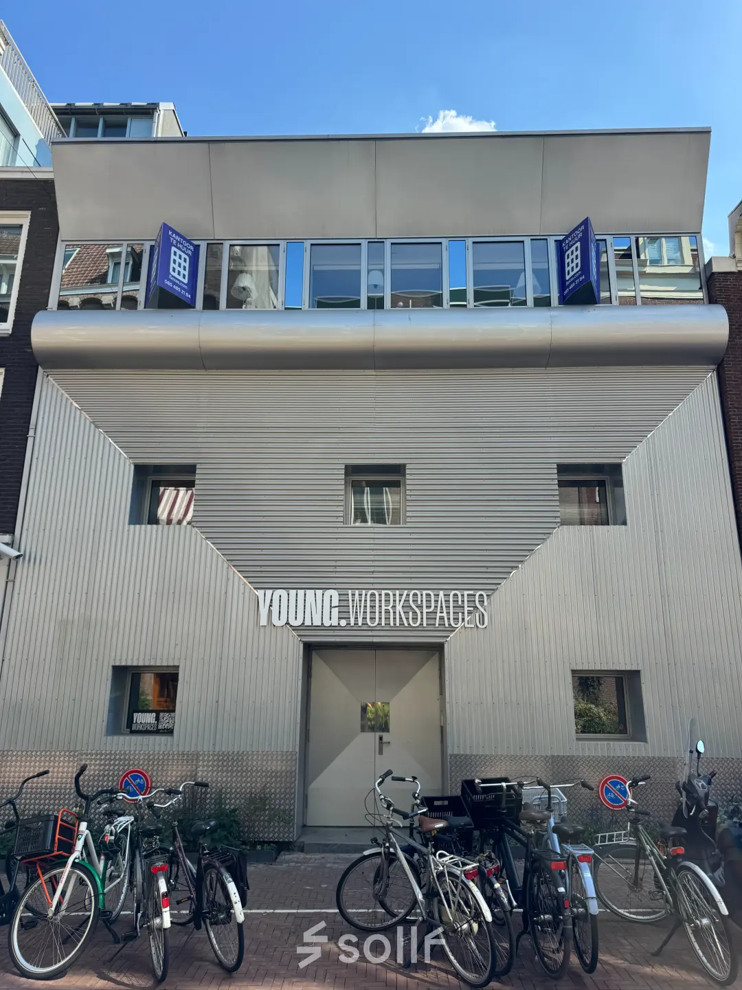Exterior view of an office building for rent at Kerkstraat 204, Amsterdam Center, featuring a modern facade and bicycles parked outside.