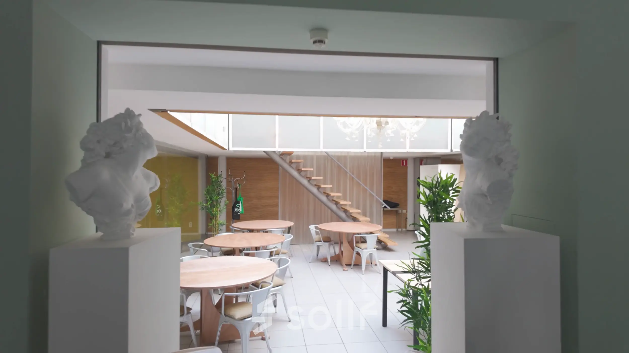 Spacious office area at Kerkstraat 204, Amsterdam Center, featuring round tables, chairs, and greenery ideal for office space rental.